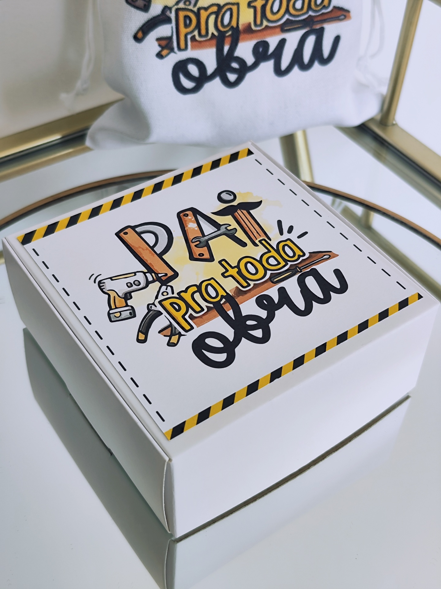 Caixa branca de cartão com tampa decorada com texto 'Pai pra toda obra' e desenhos de ferramentas