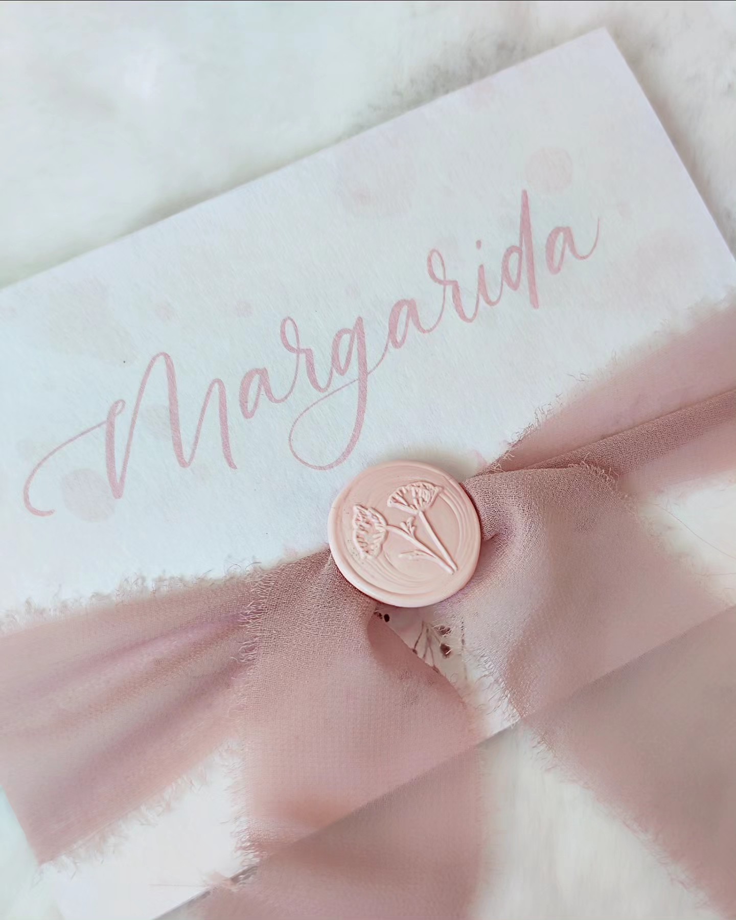 Envelope branco com nome Margarida, fita rosa e selo de cera com flores