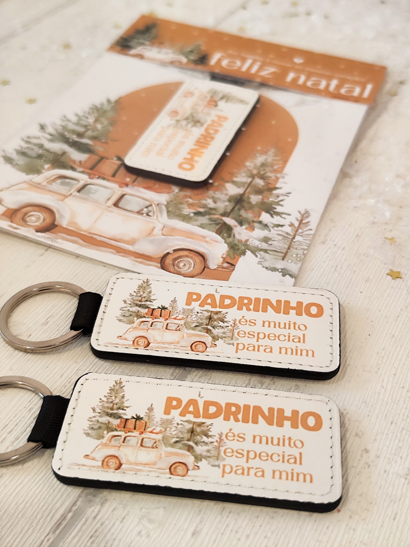 Porta-chaves em couro branco com desenho de carro e árvore de Natal e texto em português