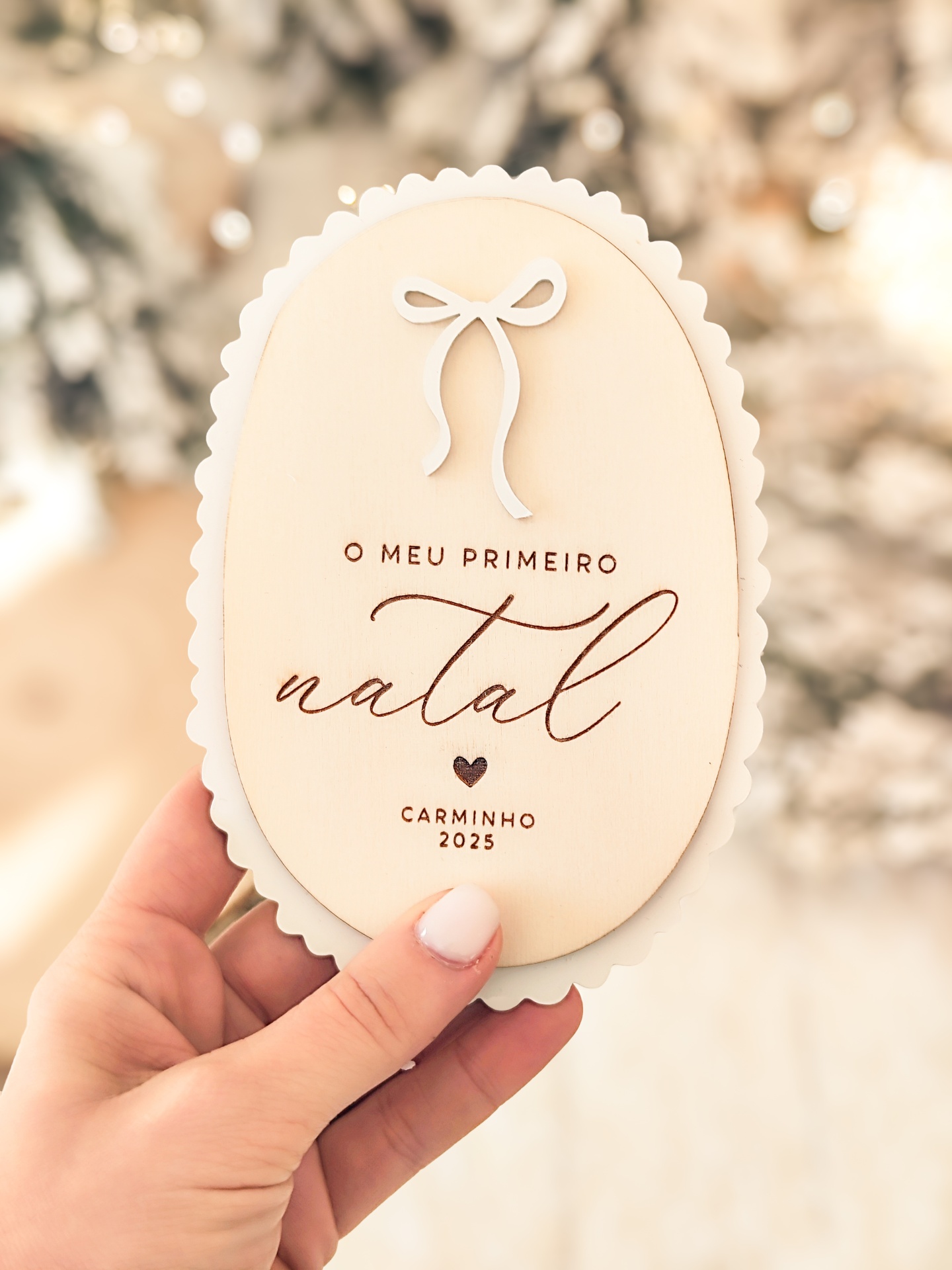 Enfeite oval de madeira com texto gravado sobre fundo desfocado