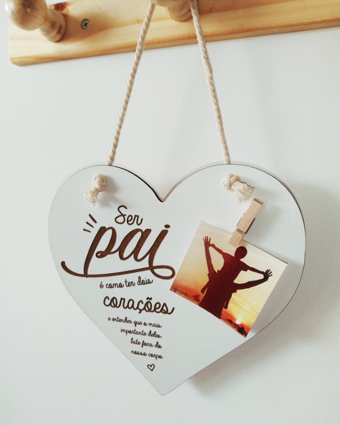 Placa em forma de coração com texto sobre paternidade e fotografia presa por mini pregador