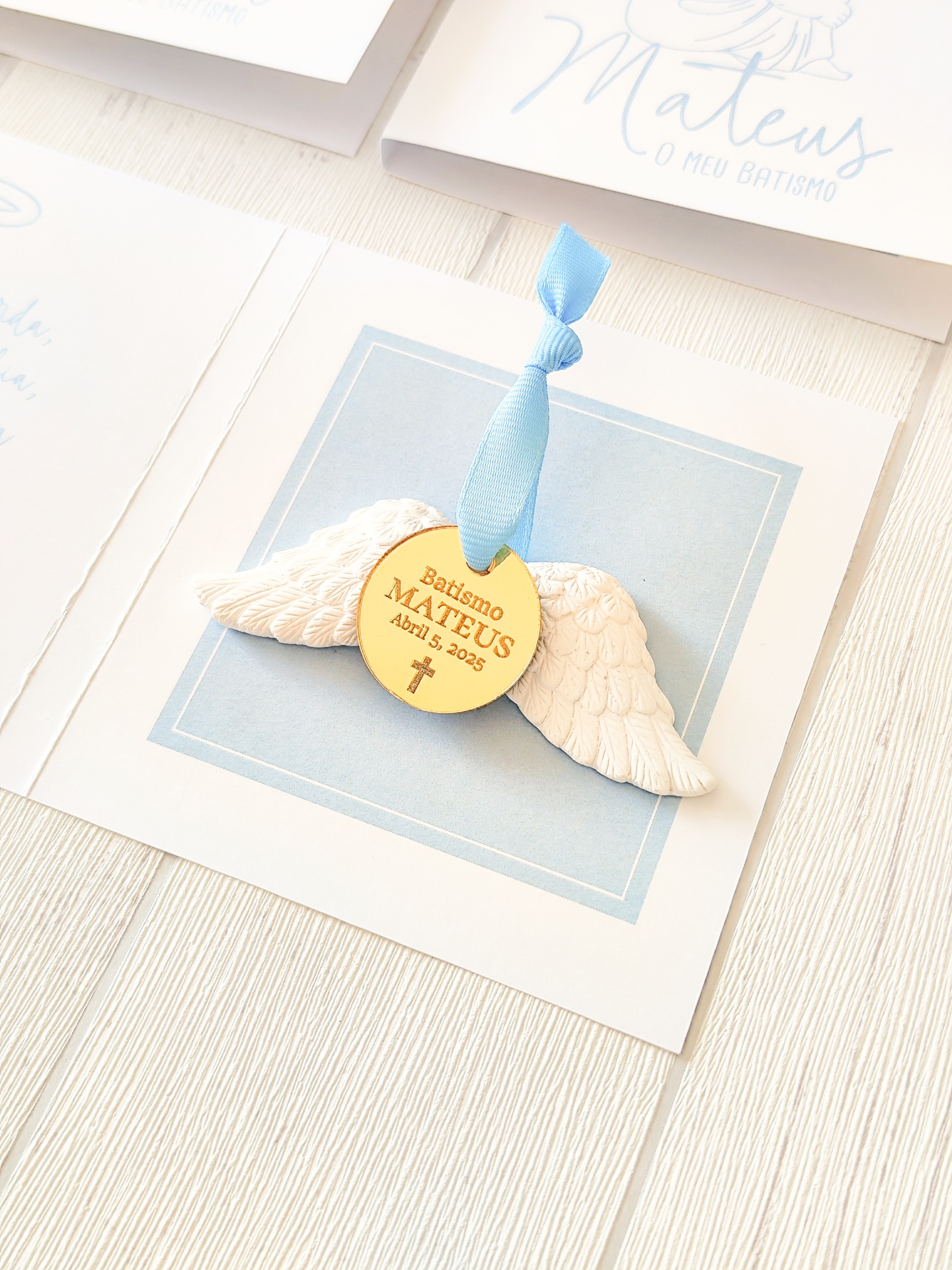 Marcador de páginas para batismo com asas e medalha dourada pendurada por fita azul