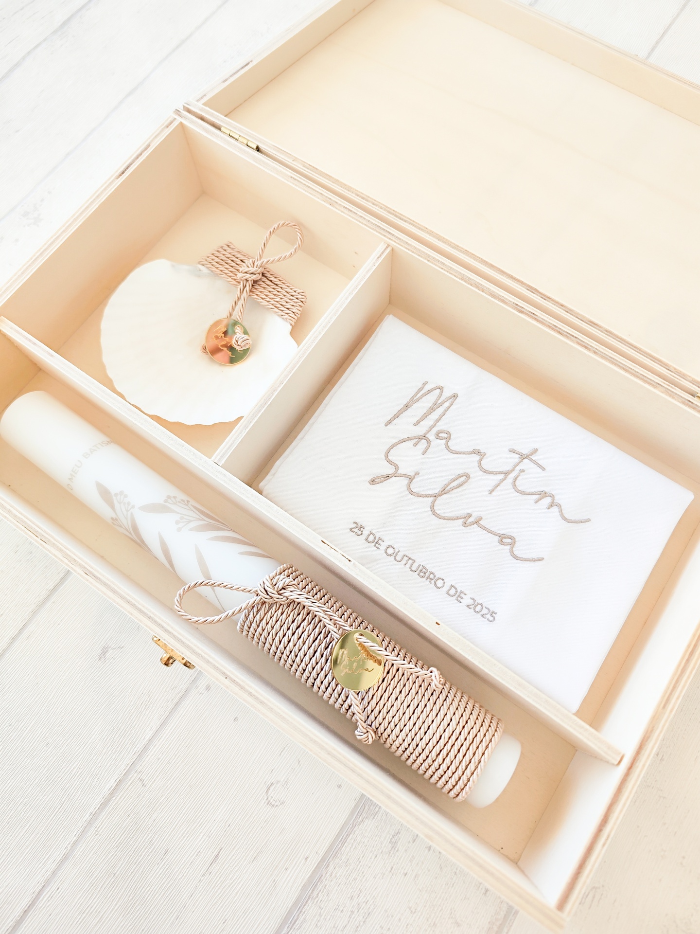 Caixa de madeira organizada com vela, concha e pano branco bordado