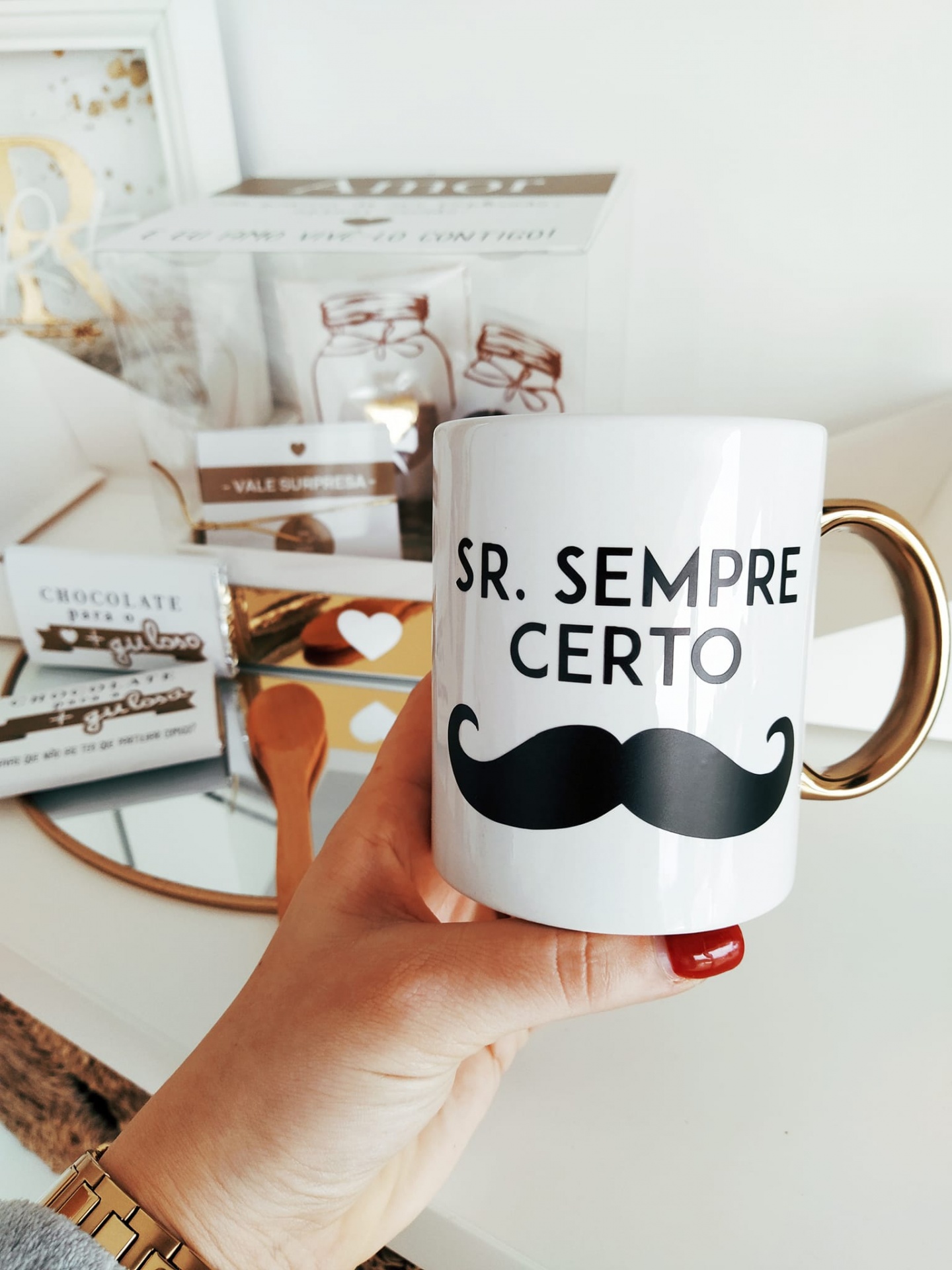 Caneca branca com texto e bigode, com fundo de embalagens de chocolate e oferta