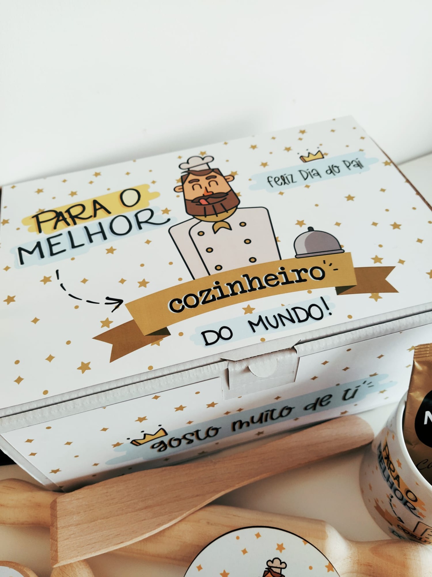 Caixa branca decorada para o melhor cozinheiro do mundo com ilustração e textos, utensílios de cozinha em madeira e saco de papel