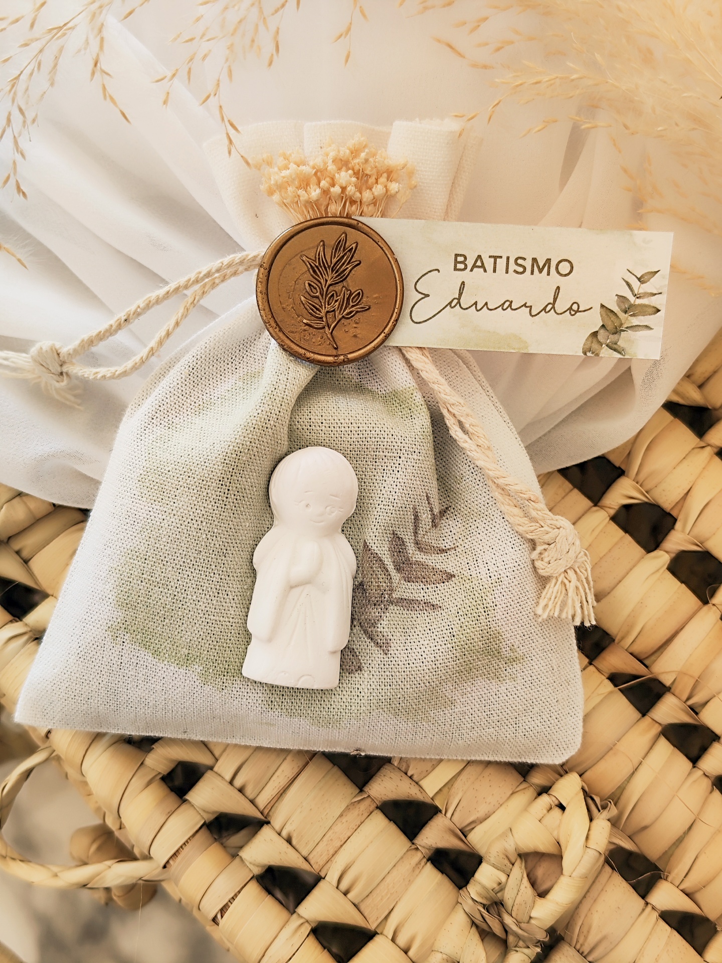 Saco tecido cinza claro com figura de criança em cerâmica e etiqueta BATISMO Eduardo