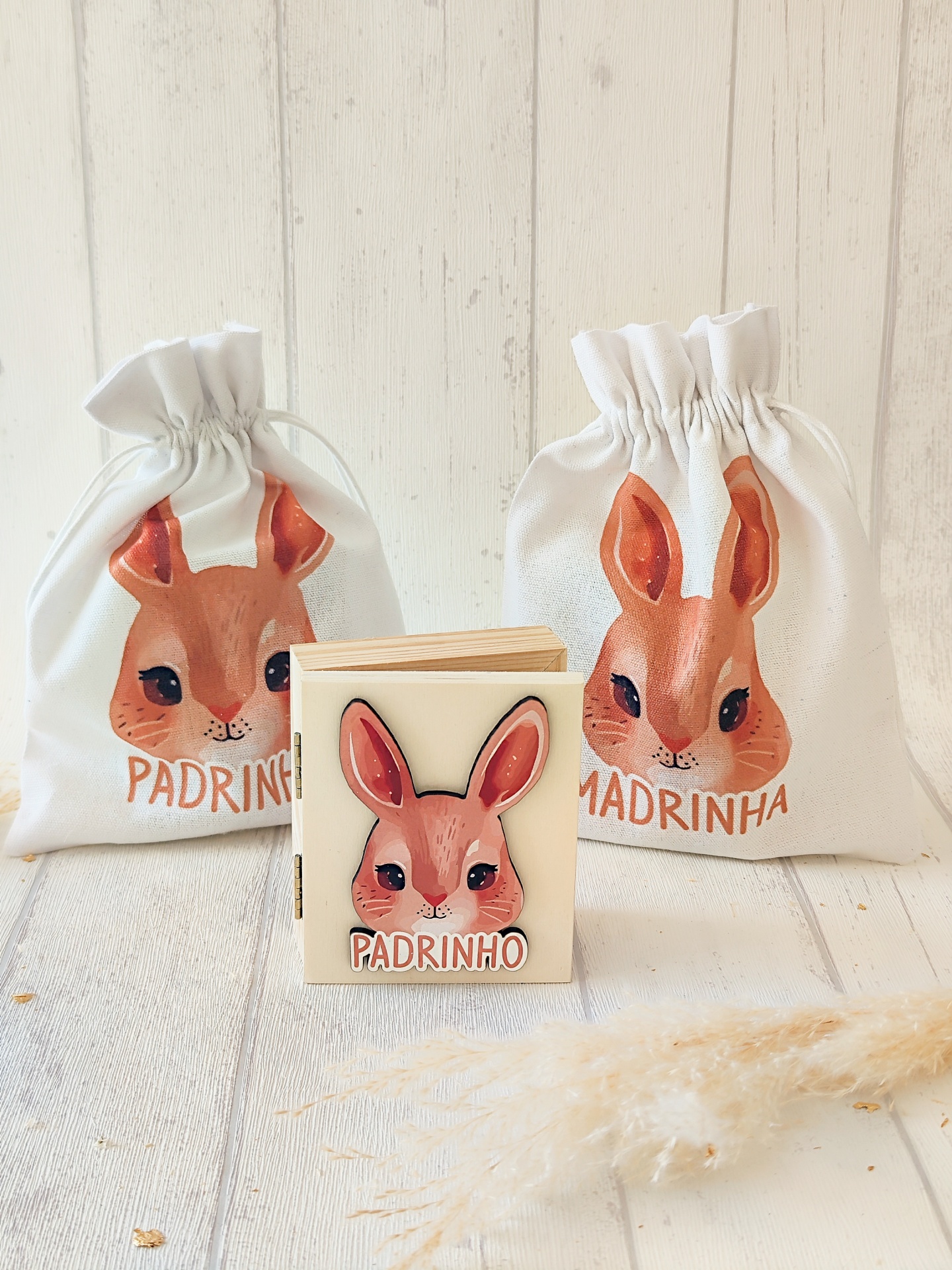 Sacos de pano e bloco de notas com imagem de coelho e texto padrinho/madrinha