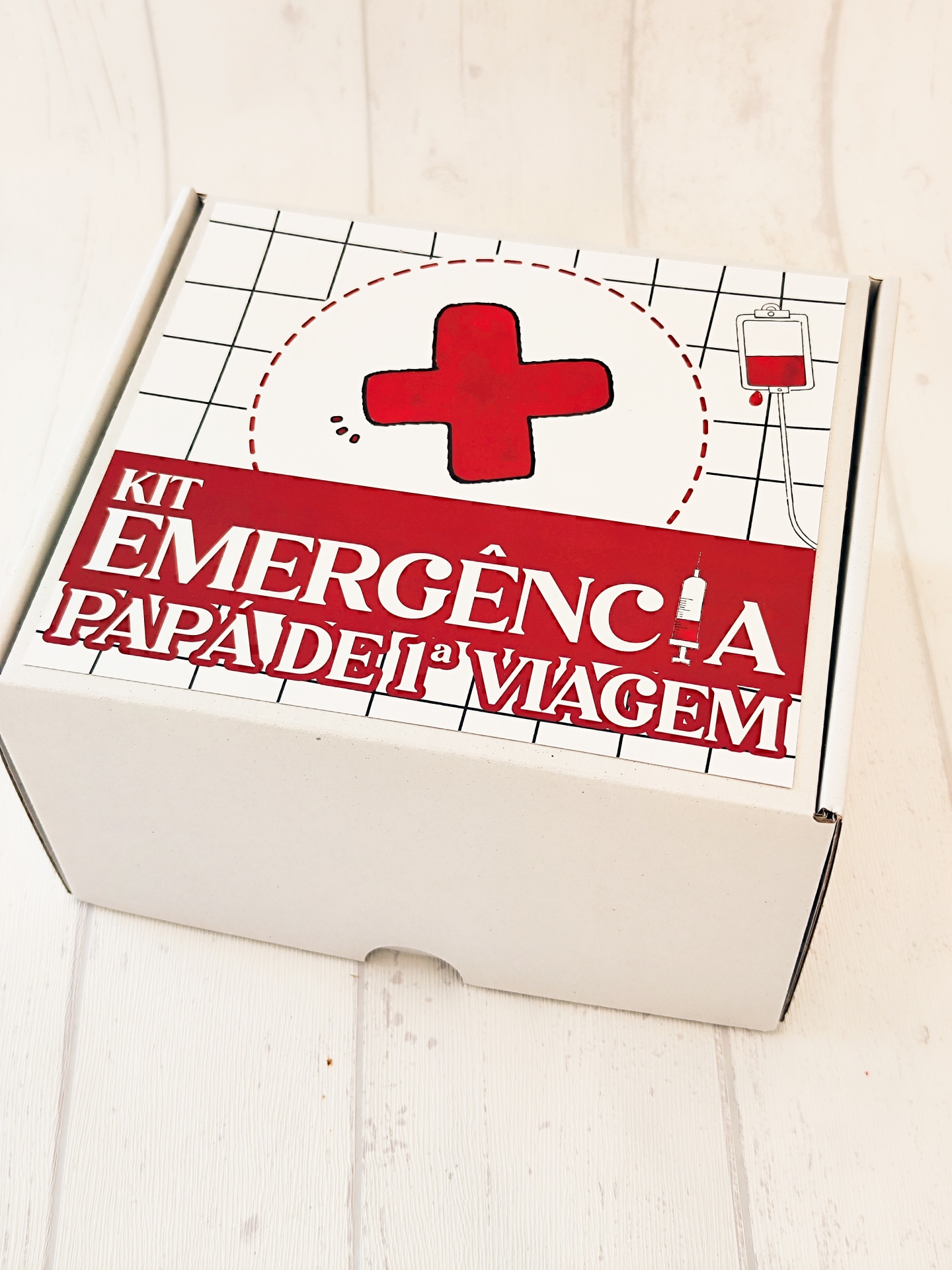 Caixa branca com etiqueta de kit de emergência para pais de primeira viagem