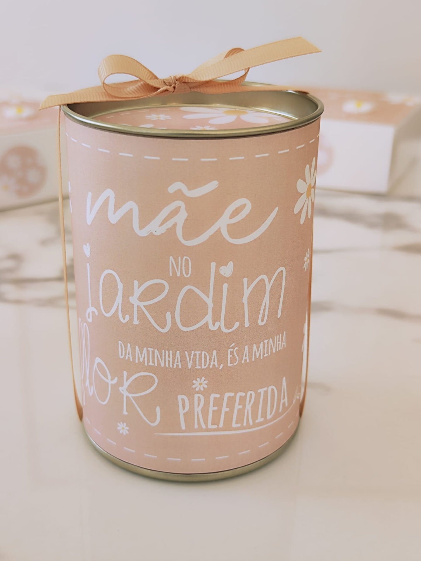 Lata decorativa cor-de-rosa com texto branco e laço castanho claro