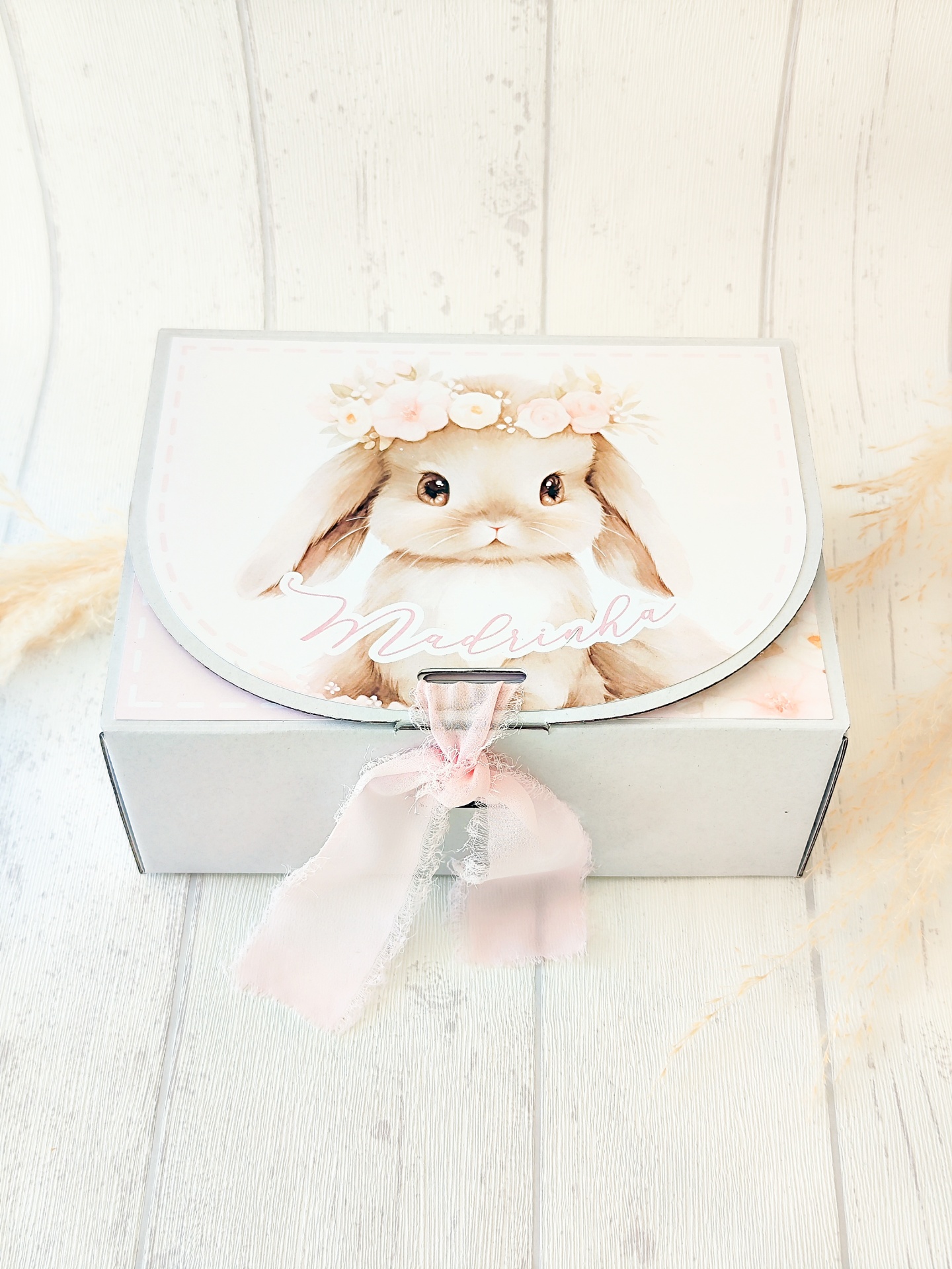 Caixa branca com imagem de coelho e laço cor-de-rosa