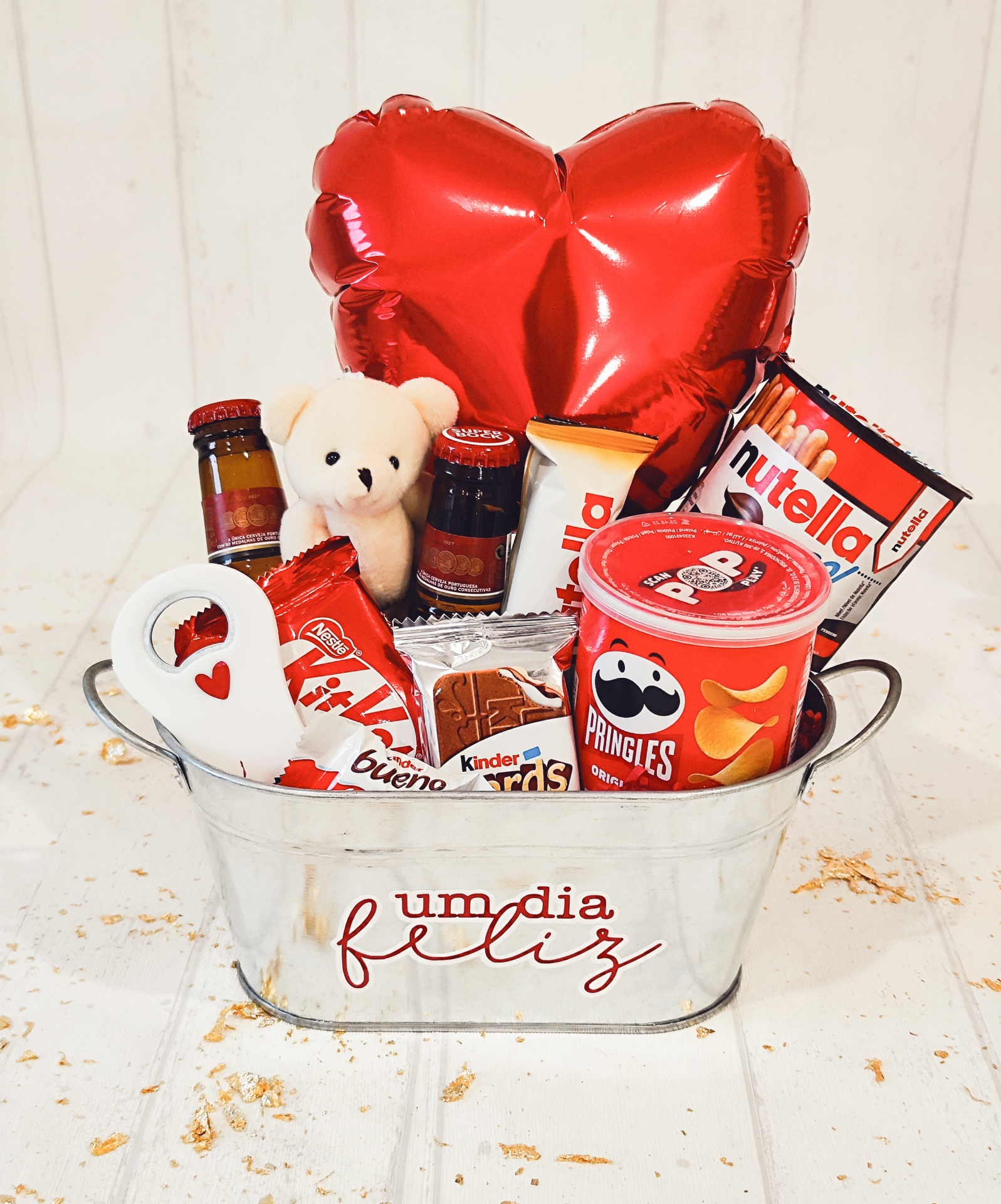 Balde metálico com snacks, brinquedo ursinho e balão vermelho em forma de coração