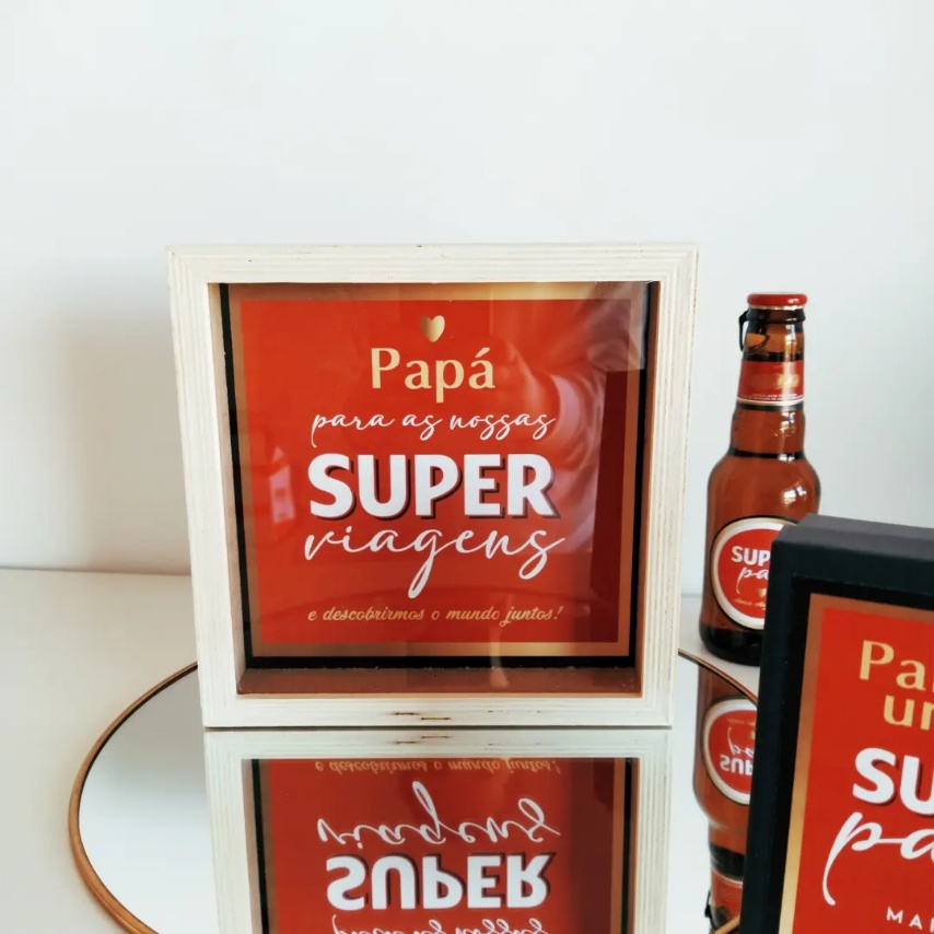 Cofre de madeira branca com texto vermelho e garrafa de cerveja com rótulo vermelho e branco