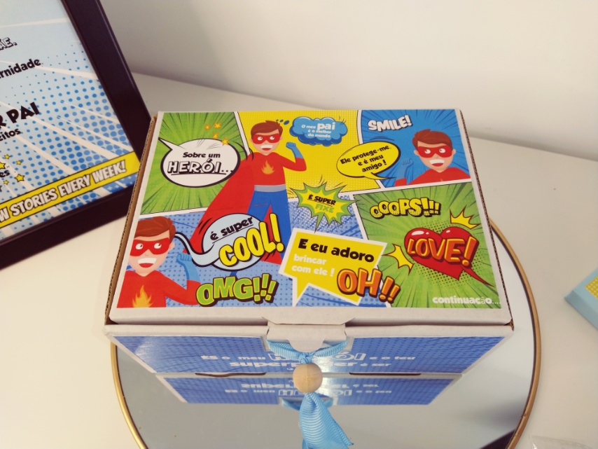 Caixa decorativa azul com ilustrações de super-heróis em cima, em estilo banda desenhada, sobre espelho