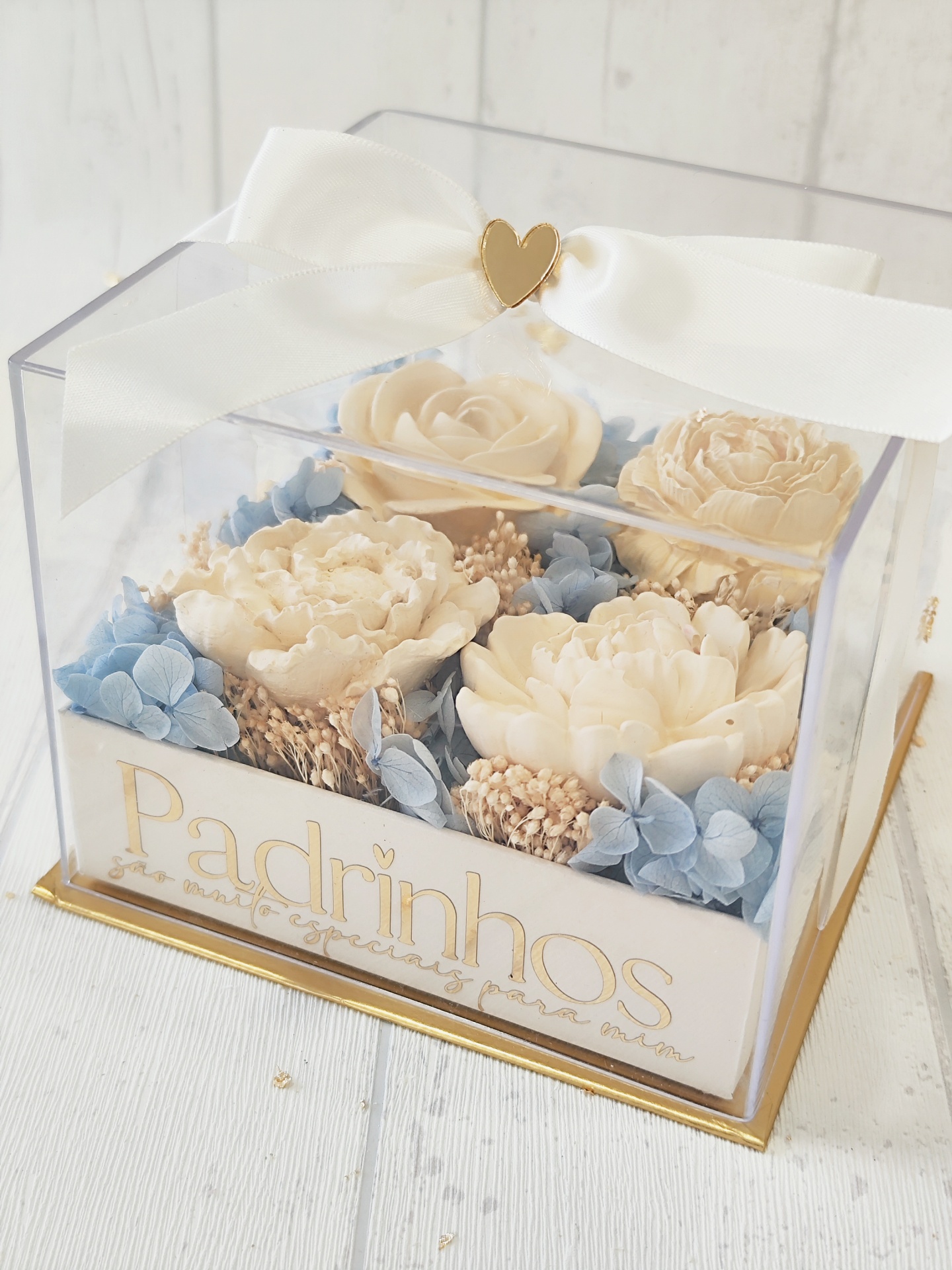 Caixa transparente com flores artificiais e laço branco decorativo