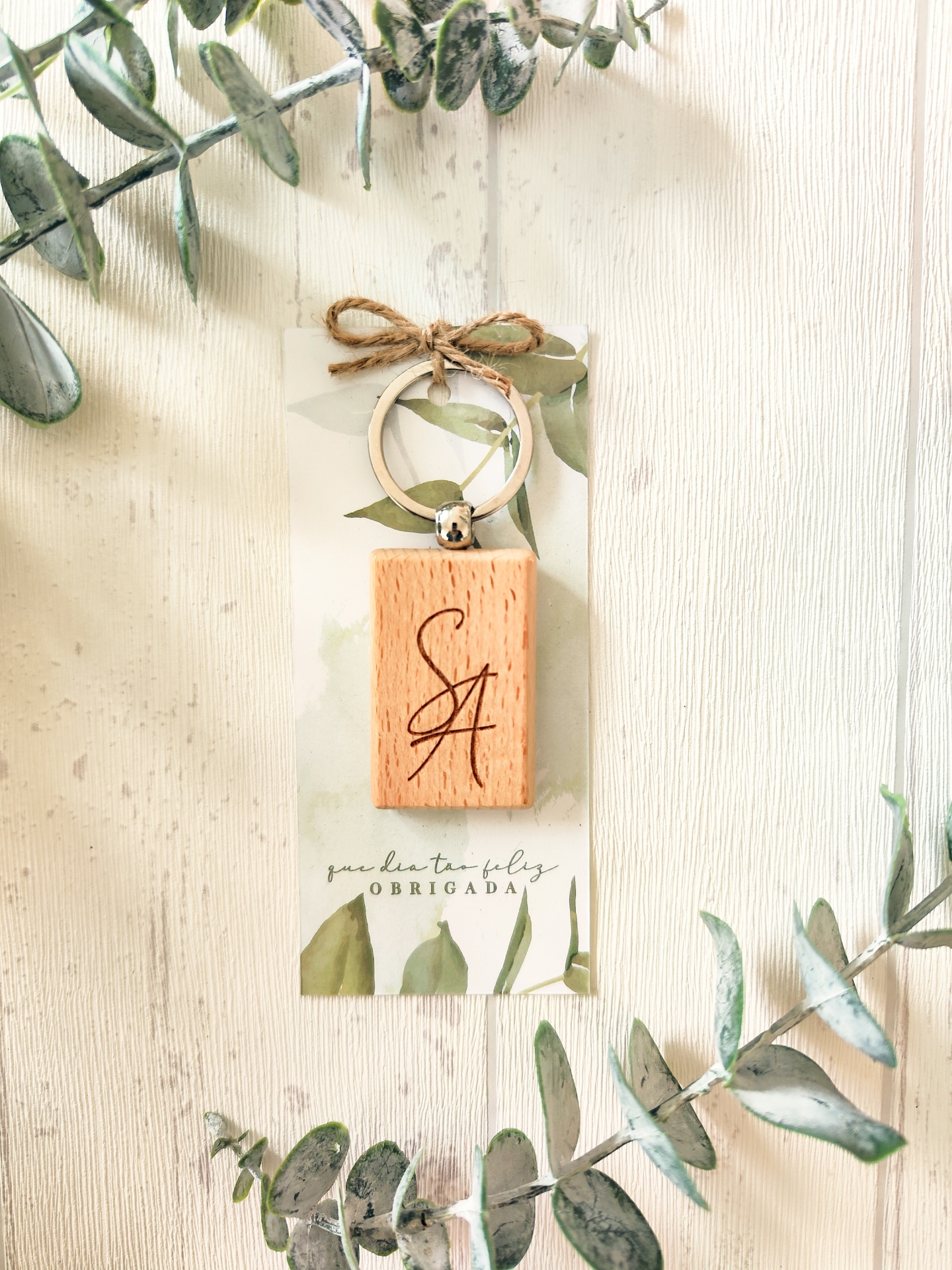 Porta-chaves de madeira com argola e cartão decorado com folhas verdes e texto