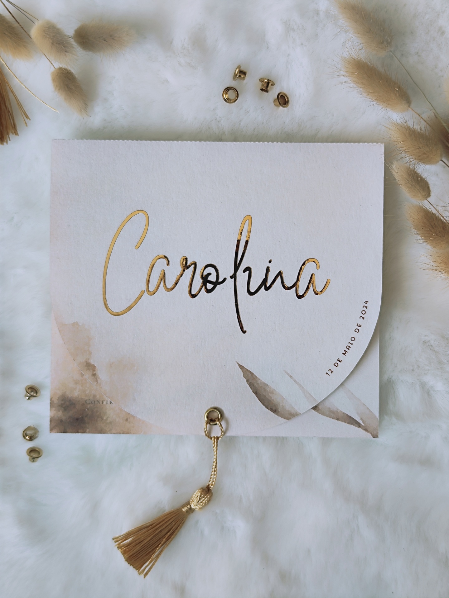 Cartão quadrado branco com nome Carolina escrito em dourado e preto e tassel cor de mostarda