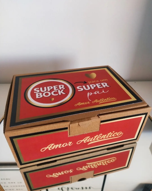 Caixa de cartão vermelha com texto SUPER BOCK, SUPER pai, Amor Autêntico sobre superfície branca