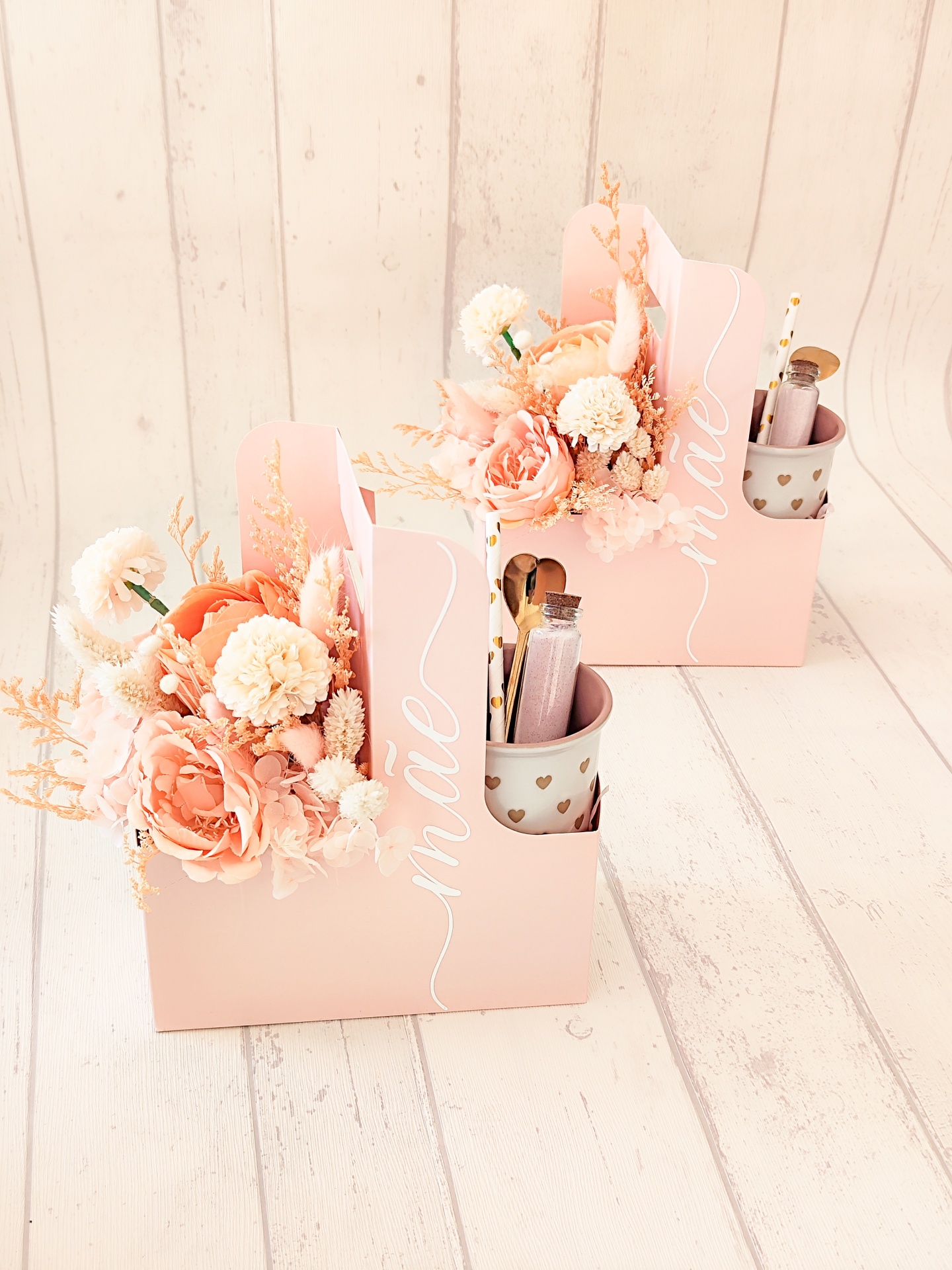 Caixas cor-de-rosa com flores artificiais e acessórios de maquilhagem