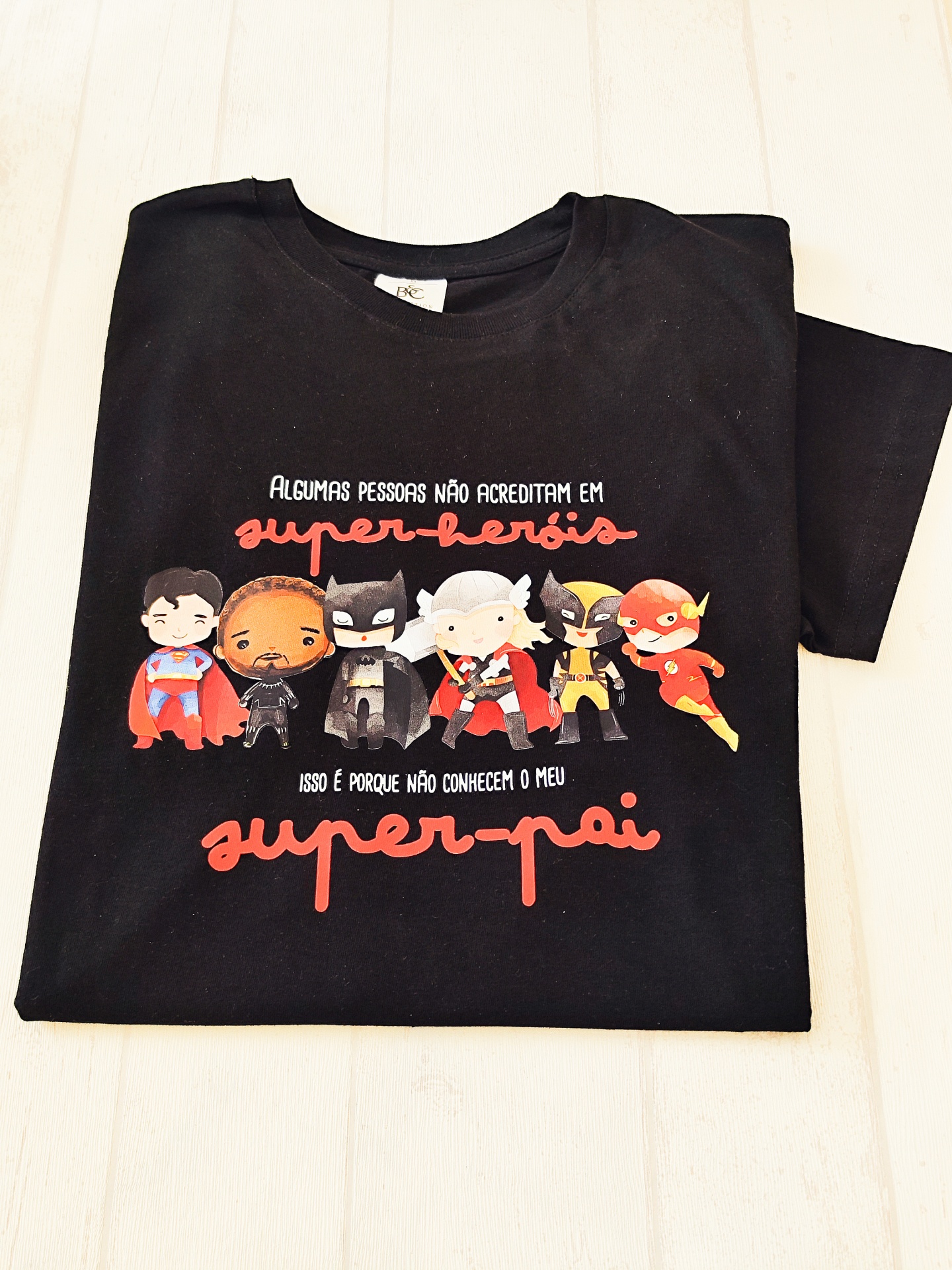 T-shirt preta com estampa de super-heróis e texto em português sobre super-pai