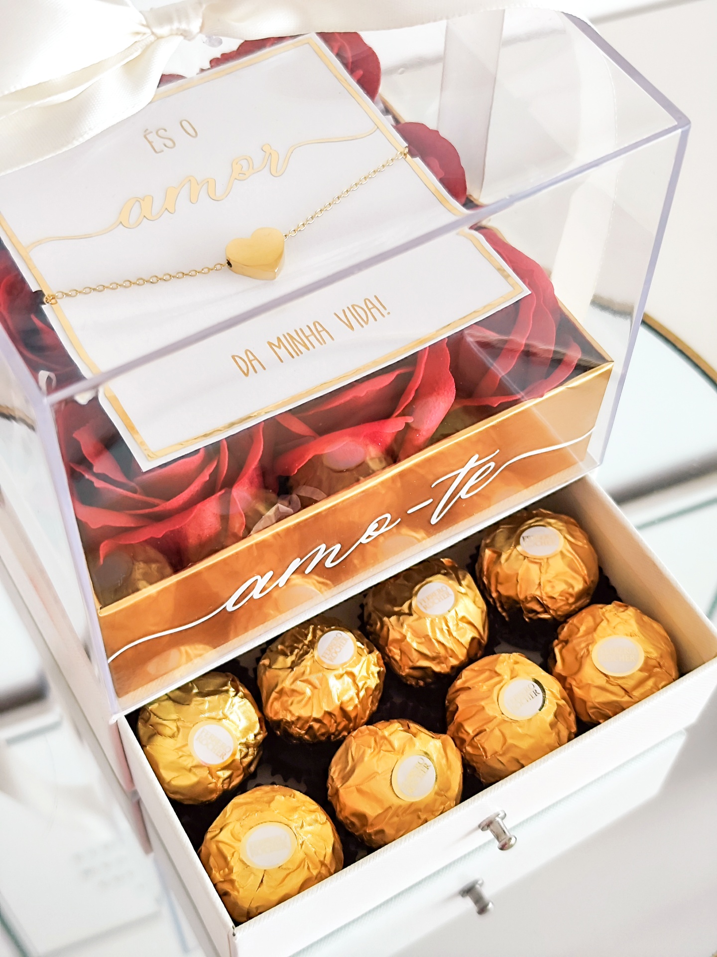 Caixa decorativa com bombons dourados, flores vermelhas, cartão e colar com coração
