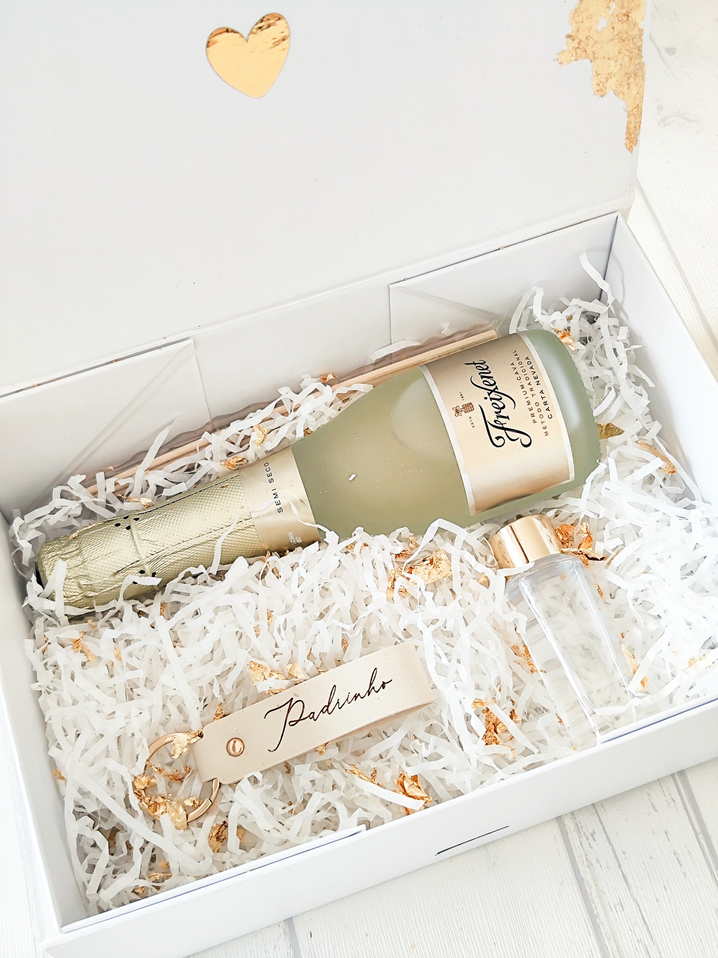 Caixa branca com garrafa de Freixenet, garrafa pequena e chaveiro com 'Padrinho'
