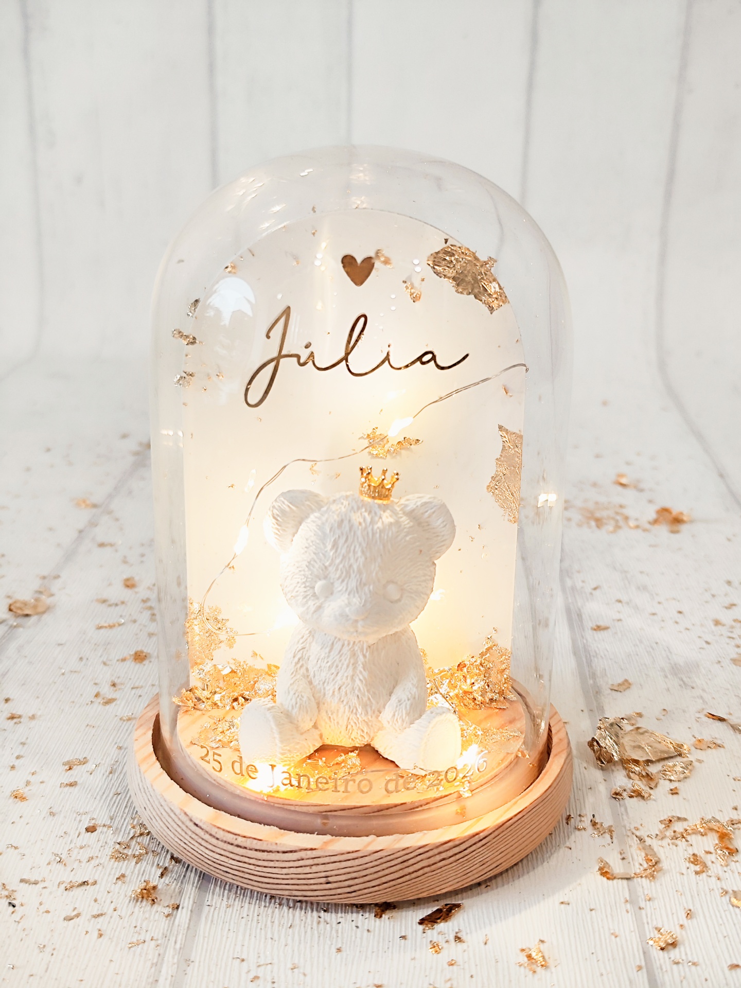 Globo de vidro com urso branco e base de madeira clara com decoração e texto