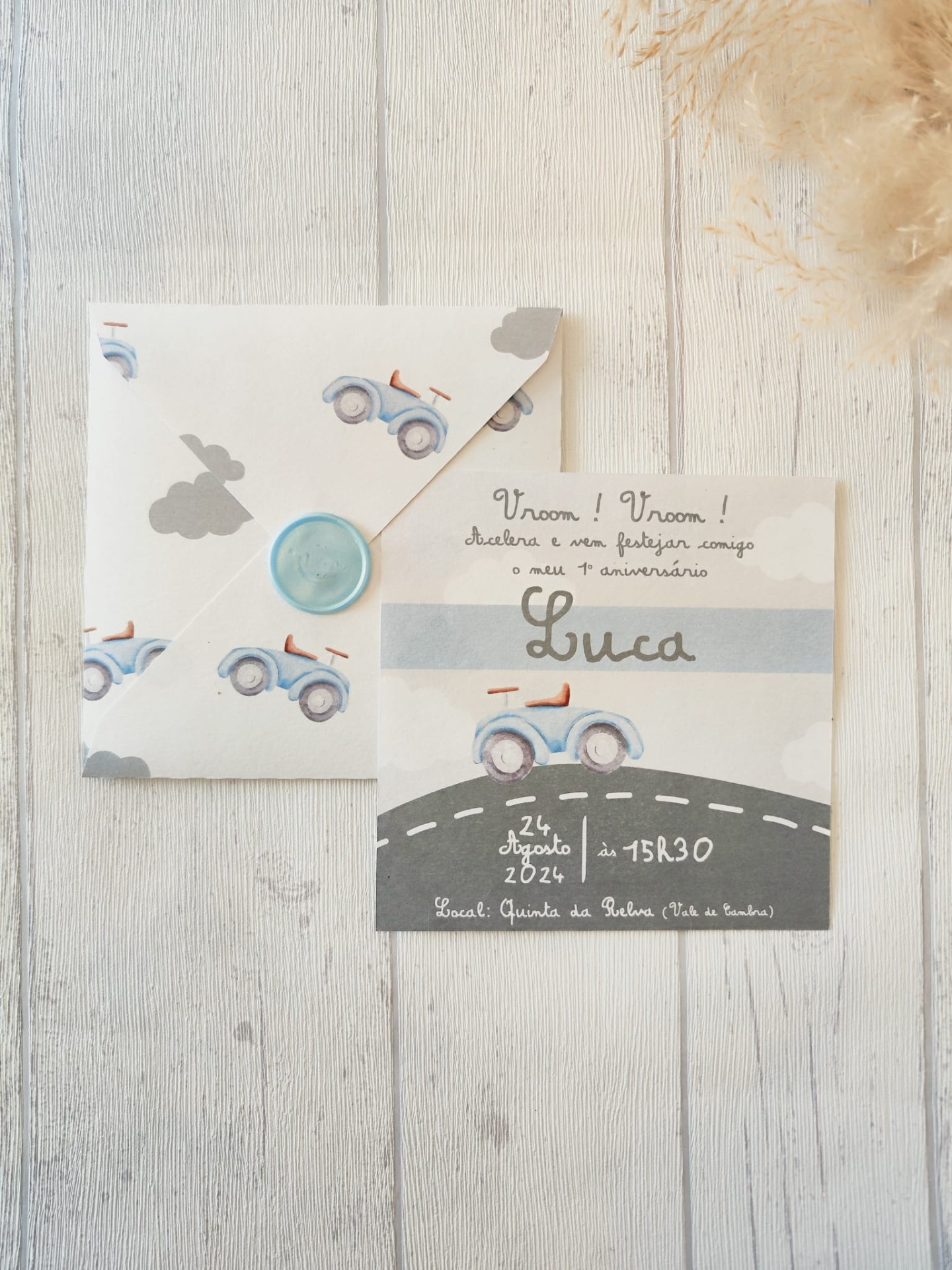 Convite e envelope de aniversário com carrinhos azuis e texto impresso em português