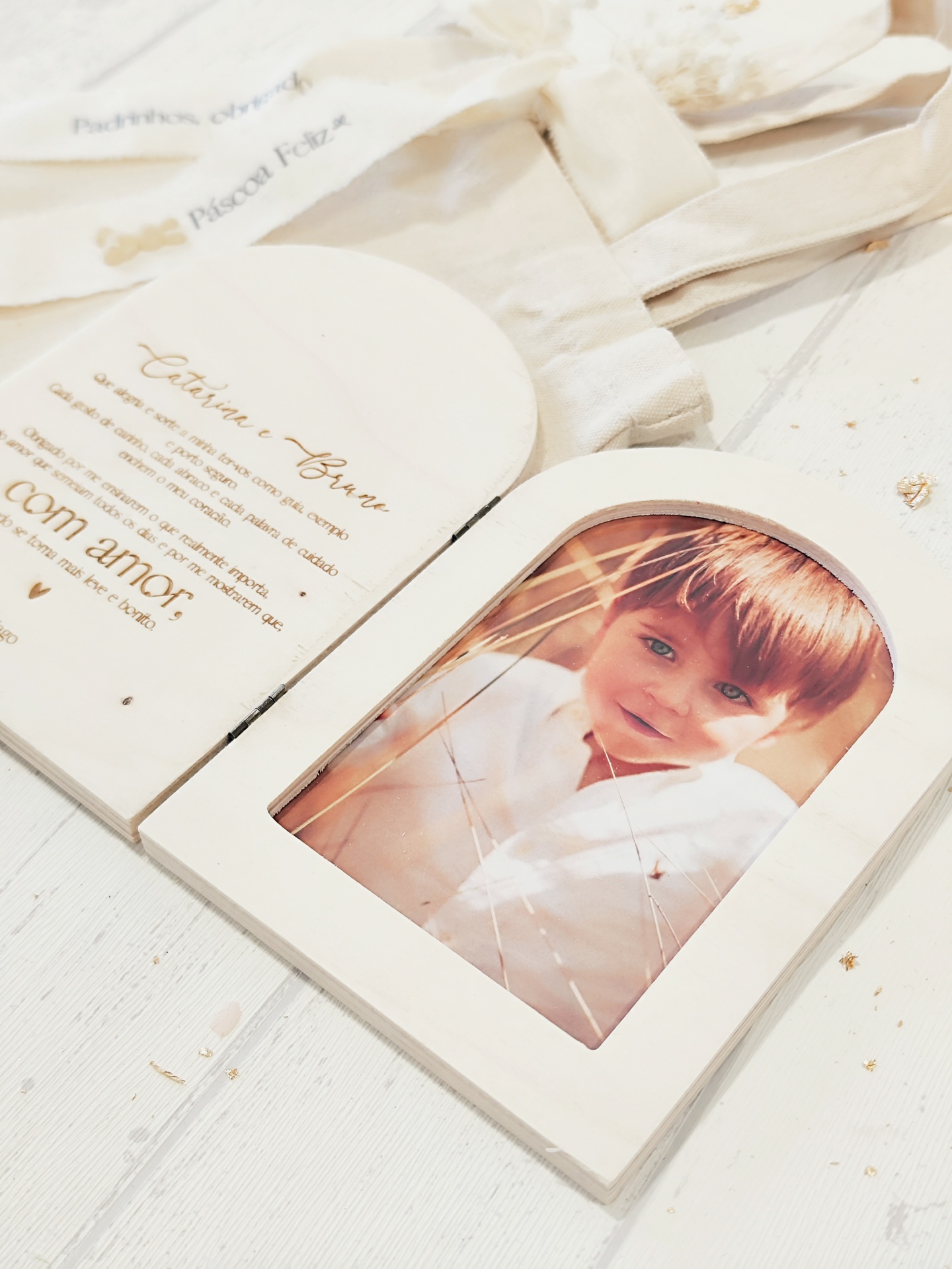 Moldura de madeira clara em forma de porta aberta com fotografia e texto em português.