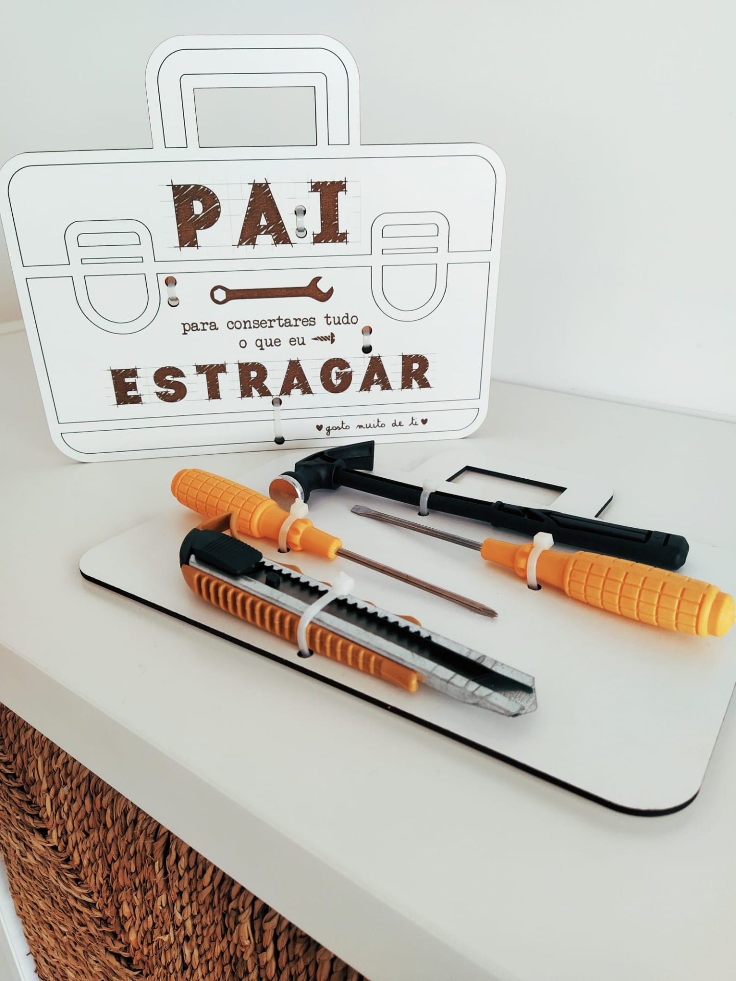 Conjunto de ferramentas com cabos laranja e preto e placa com texto em português sobre fundo branco.