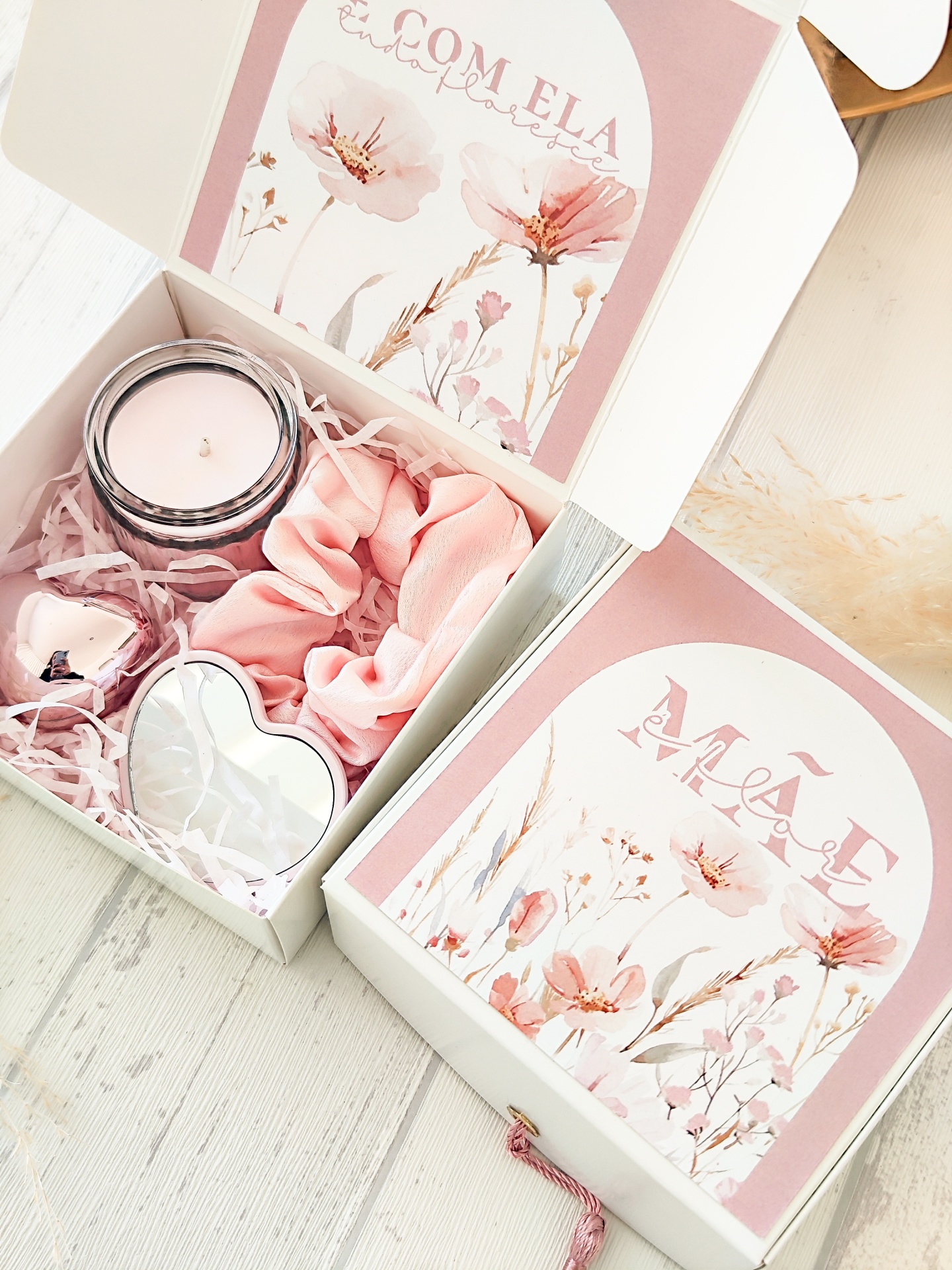 Caixa presente com vela, elástico de cabelo rosa, coração metálico e sino, com design floral rosa e branco.