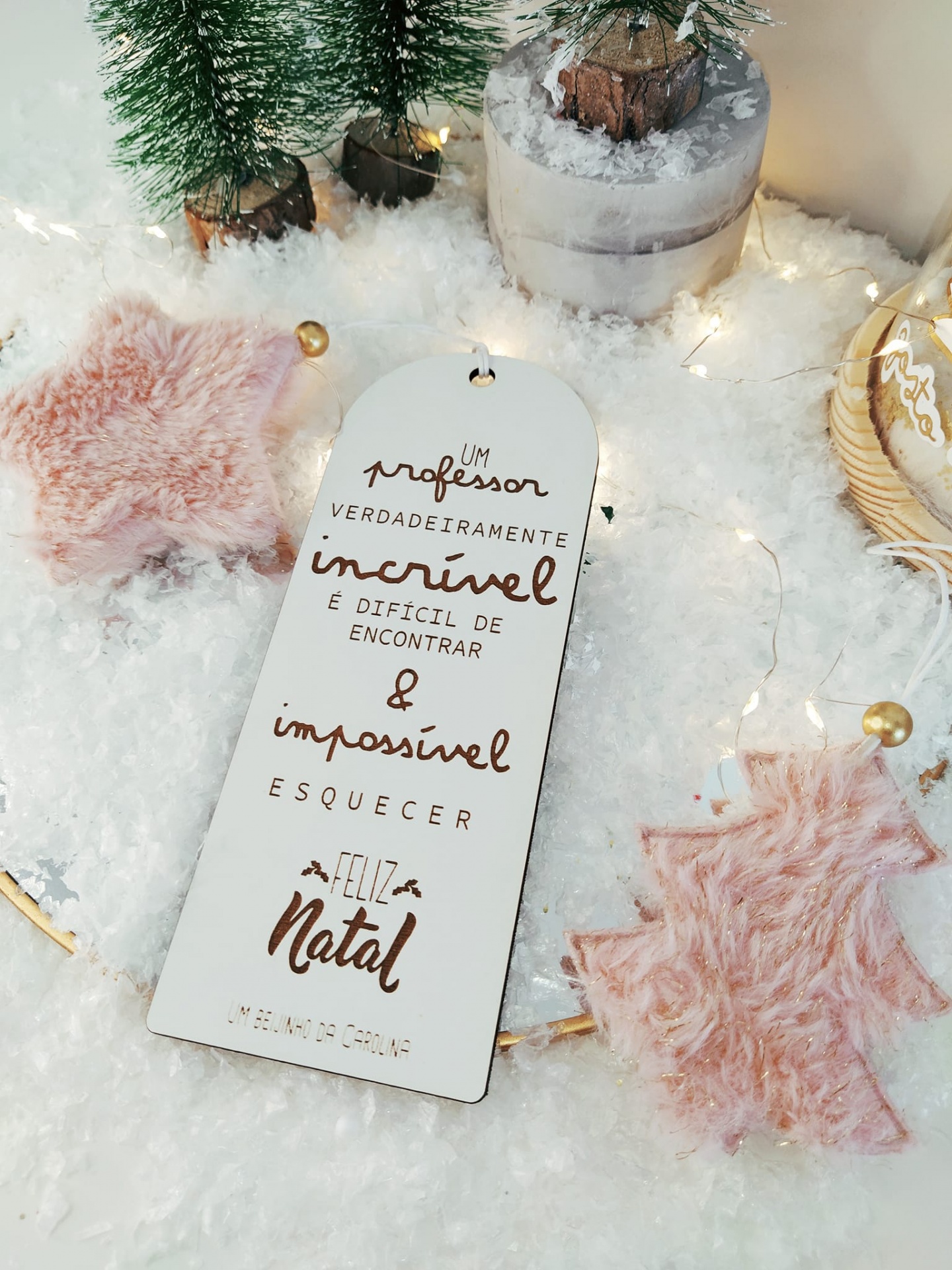 Etiqueta de Natal em madeira com texto e decoração natalícia sobre neve artificial