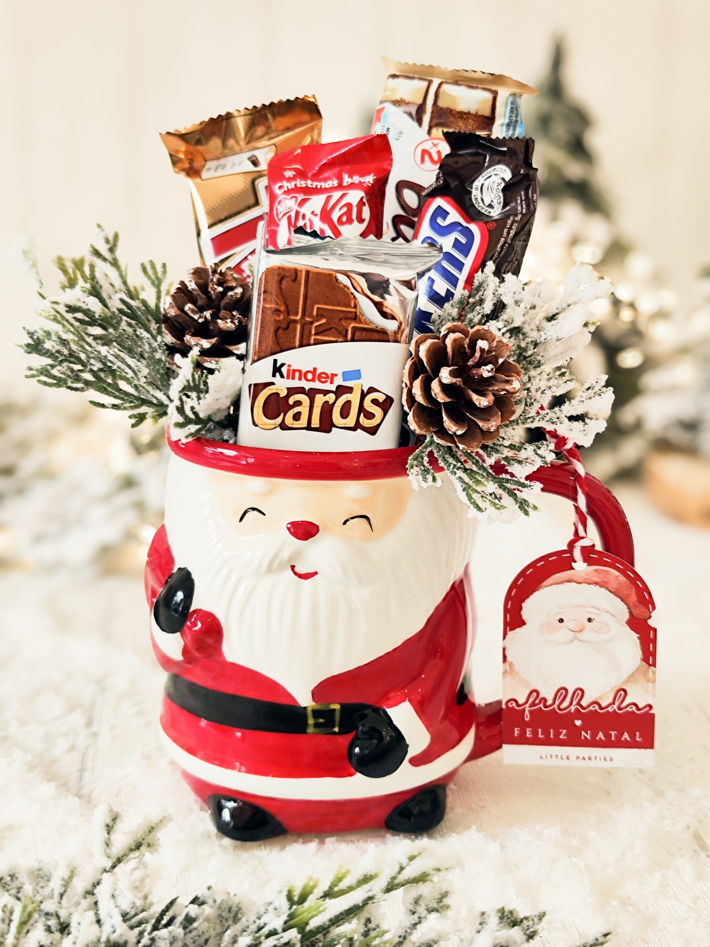 Caneca em forma de Pai Natal cheia de chocolates e decorada com pinhas e raminhos de pinheiro nevados