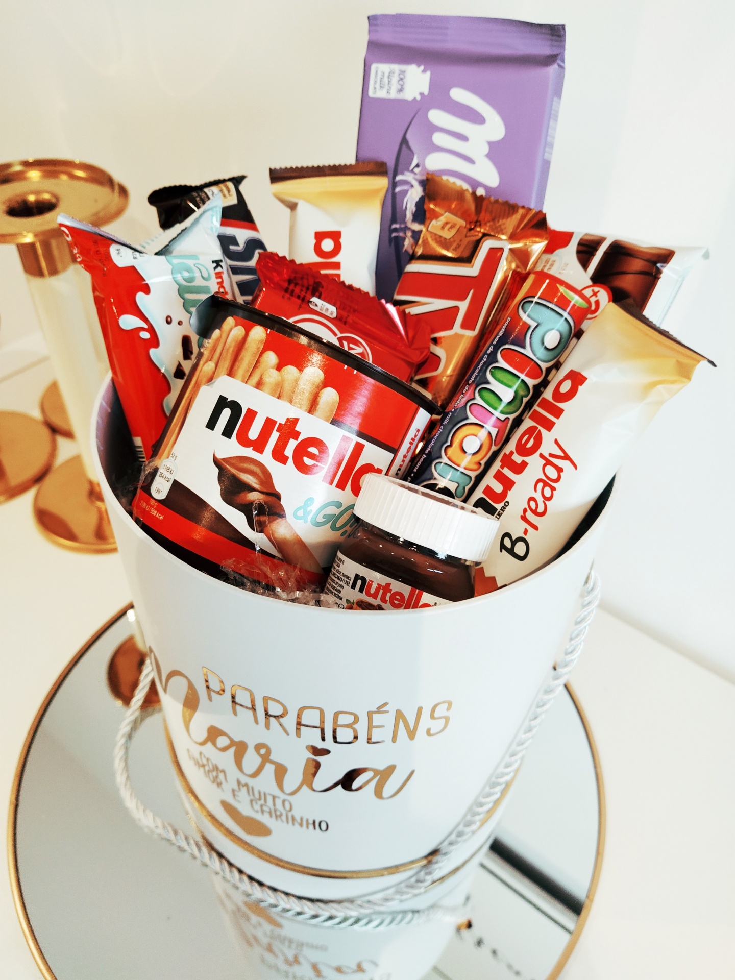 Balde branco decorado com produtos Nutella variados sobre um espelho