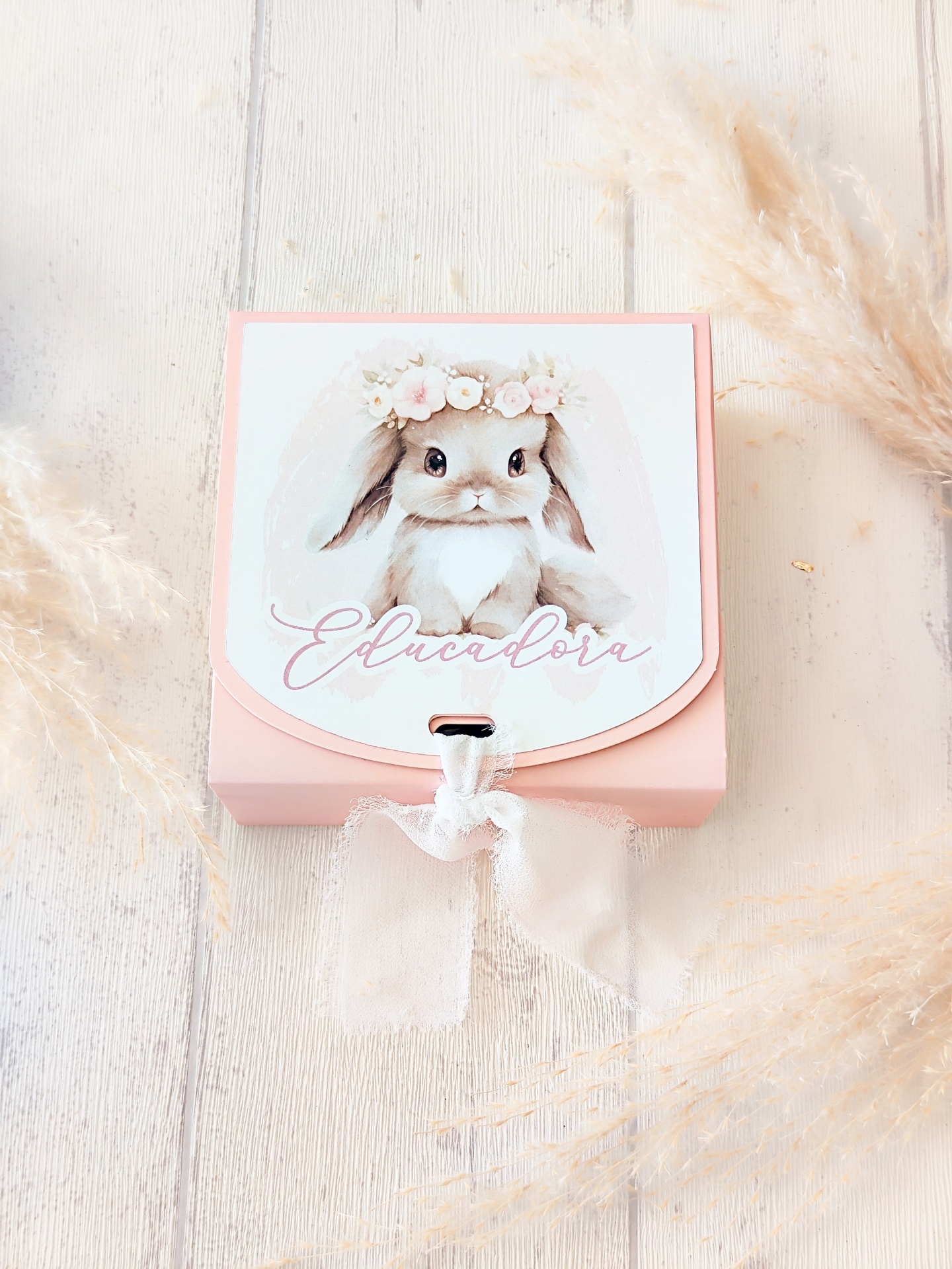 Caixa rosa com ilustração de coelho e texto Educadora