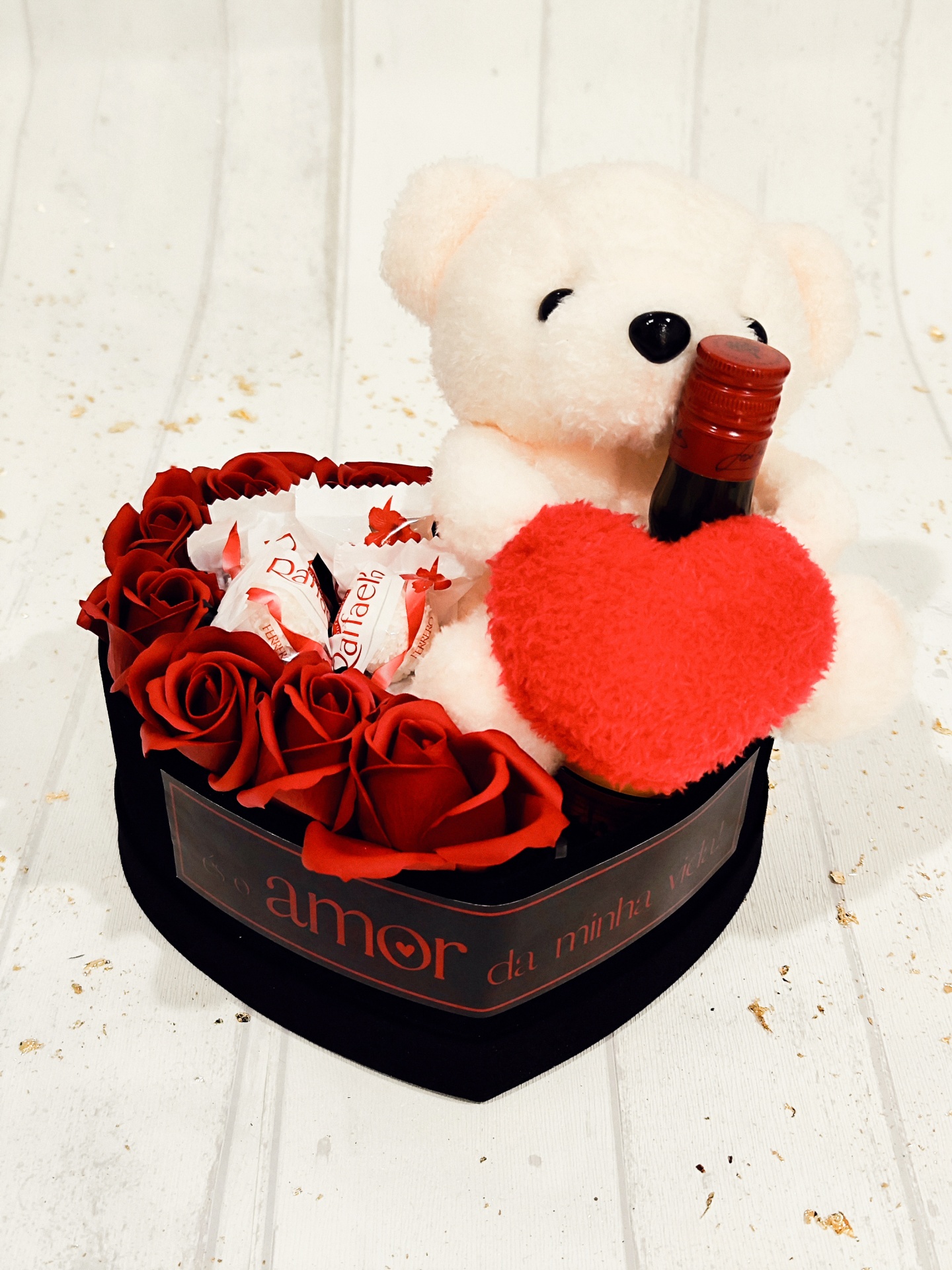Caixa coração com rosas vermelhas, ursinho branco, coração vermelho e garrafa pequena