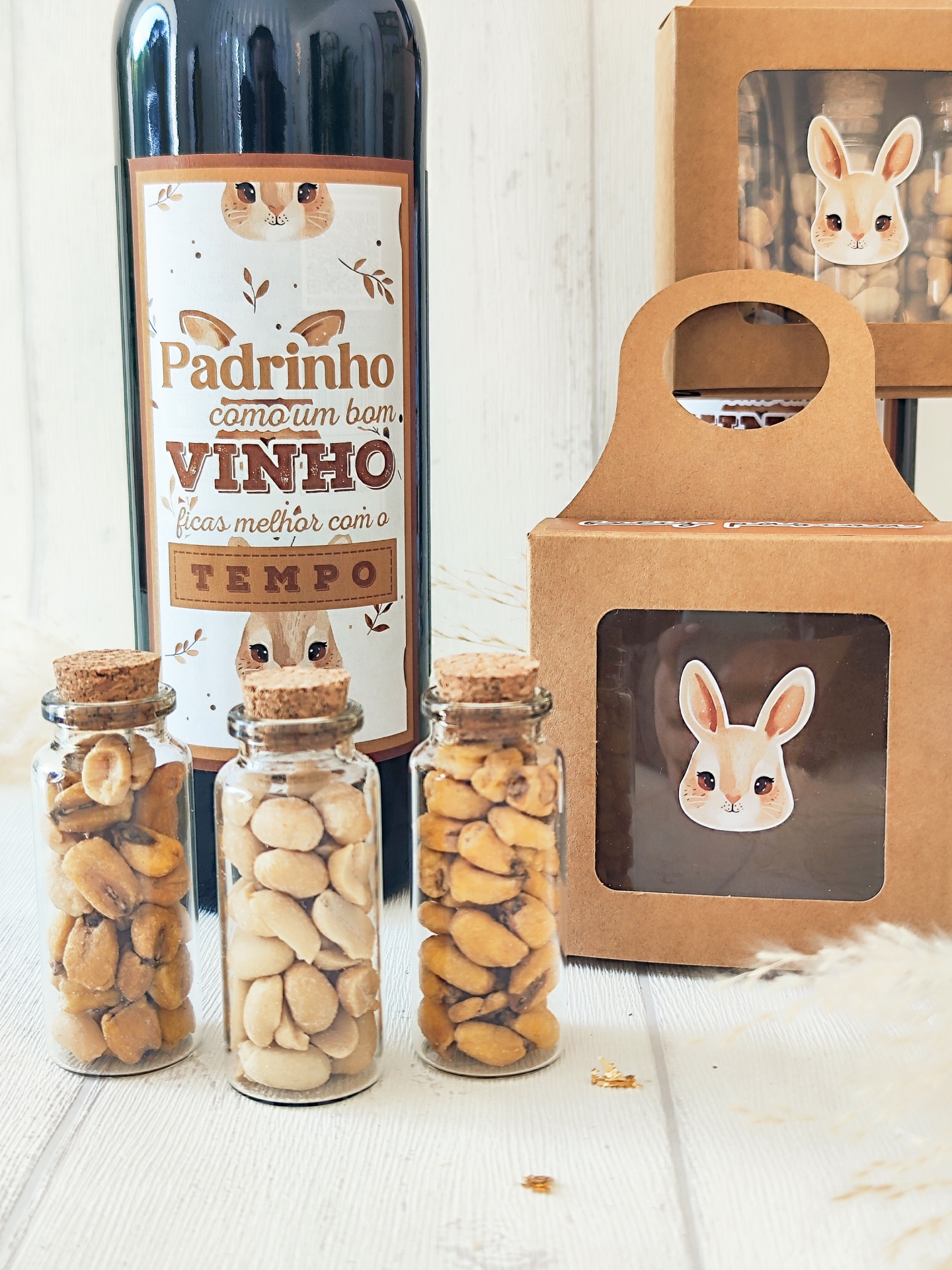 Garrafa de vinho com rótulo humorístico, frascos de vidro com amendoins e embalagens de cartão com figura de coelho