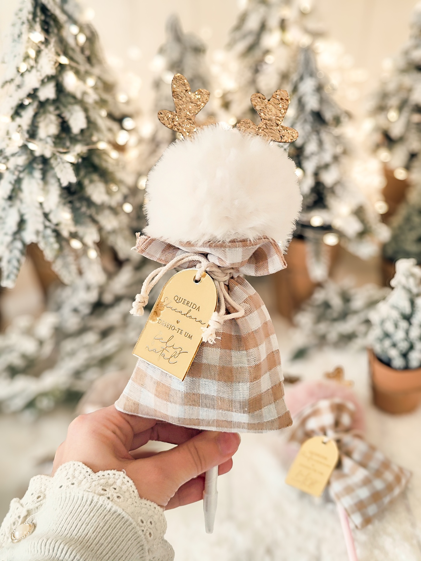 Produto de tecido xadrez castanho e branco com pompom branco e etiquetas, decorado para Natal