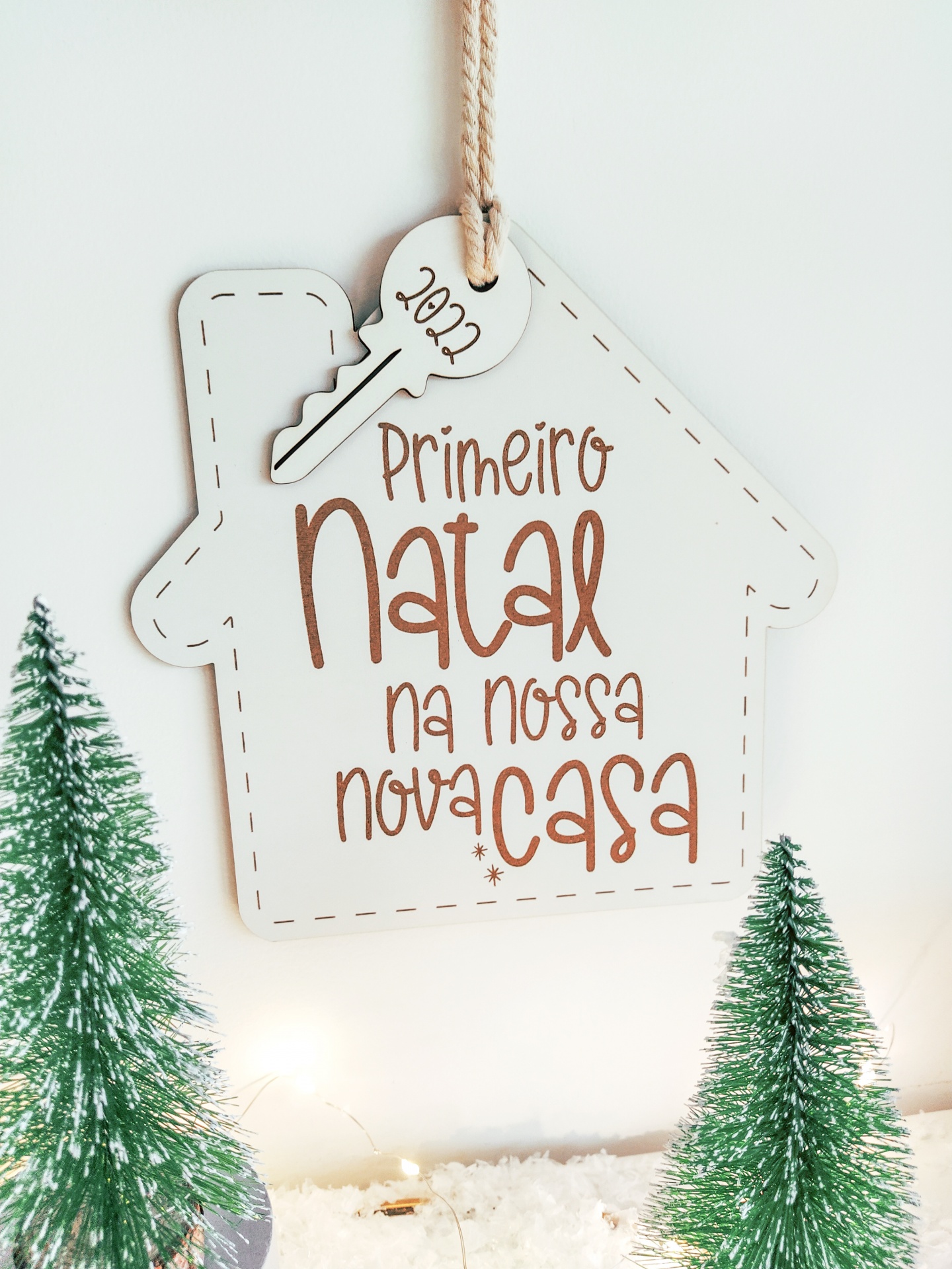 Placa decorativa de Natal em formato de casa com texto festivo e chave de madeira