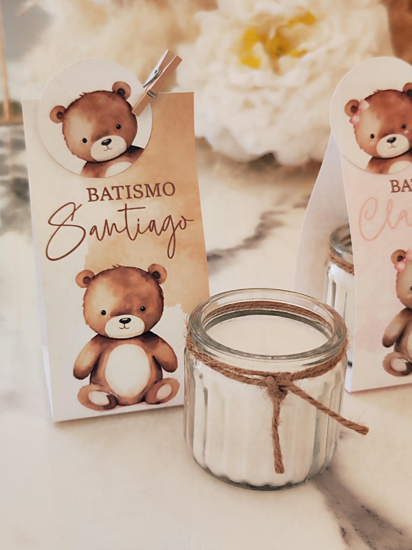 Vela branca em frasco de vidro com saco decorativo e texto BATISMO Santiago