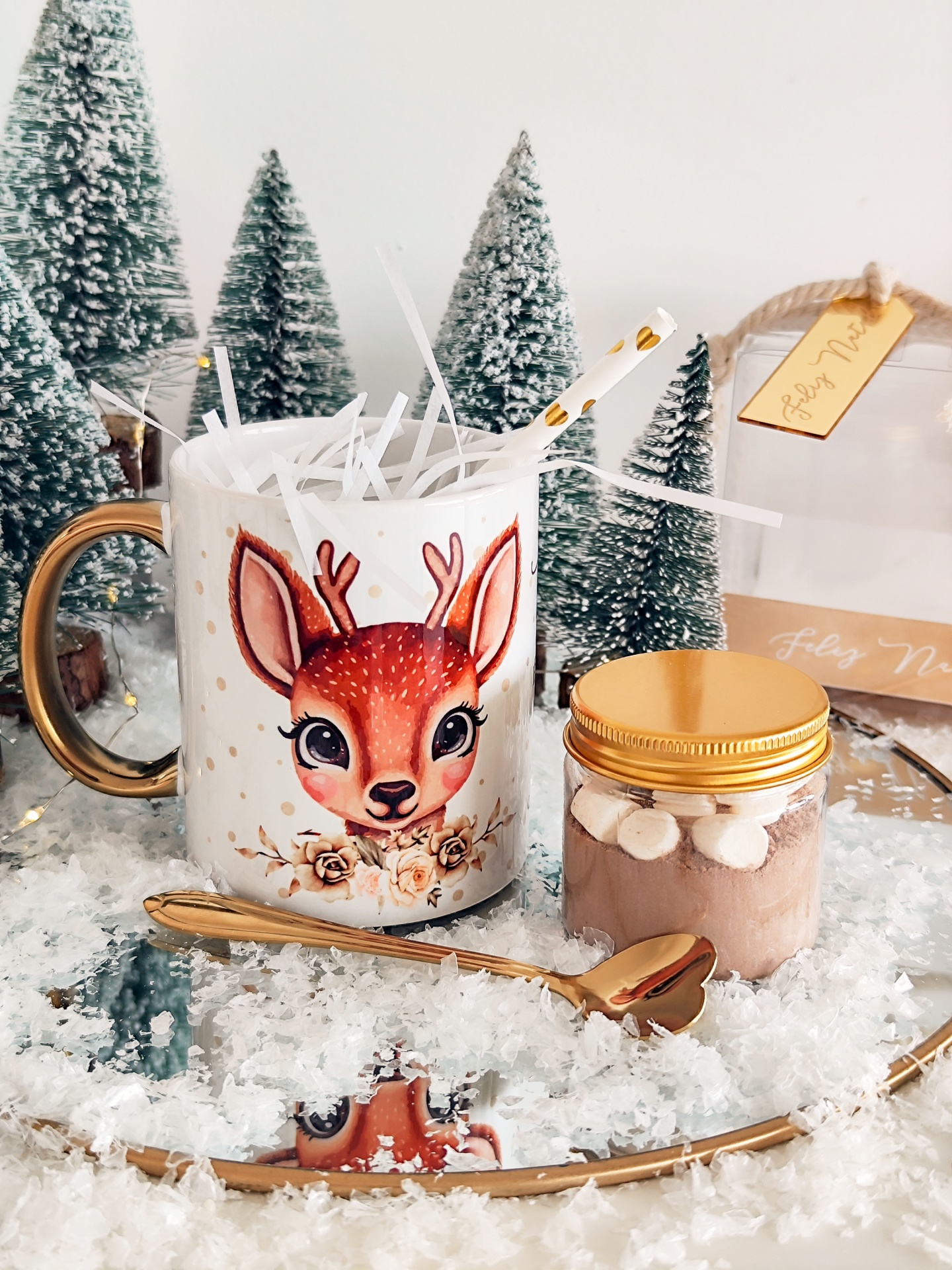 Caneca branca com cervo e frasco de doce com marshmallows em cenário de Natal