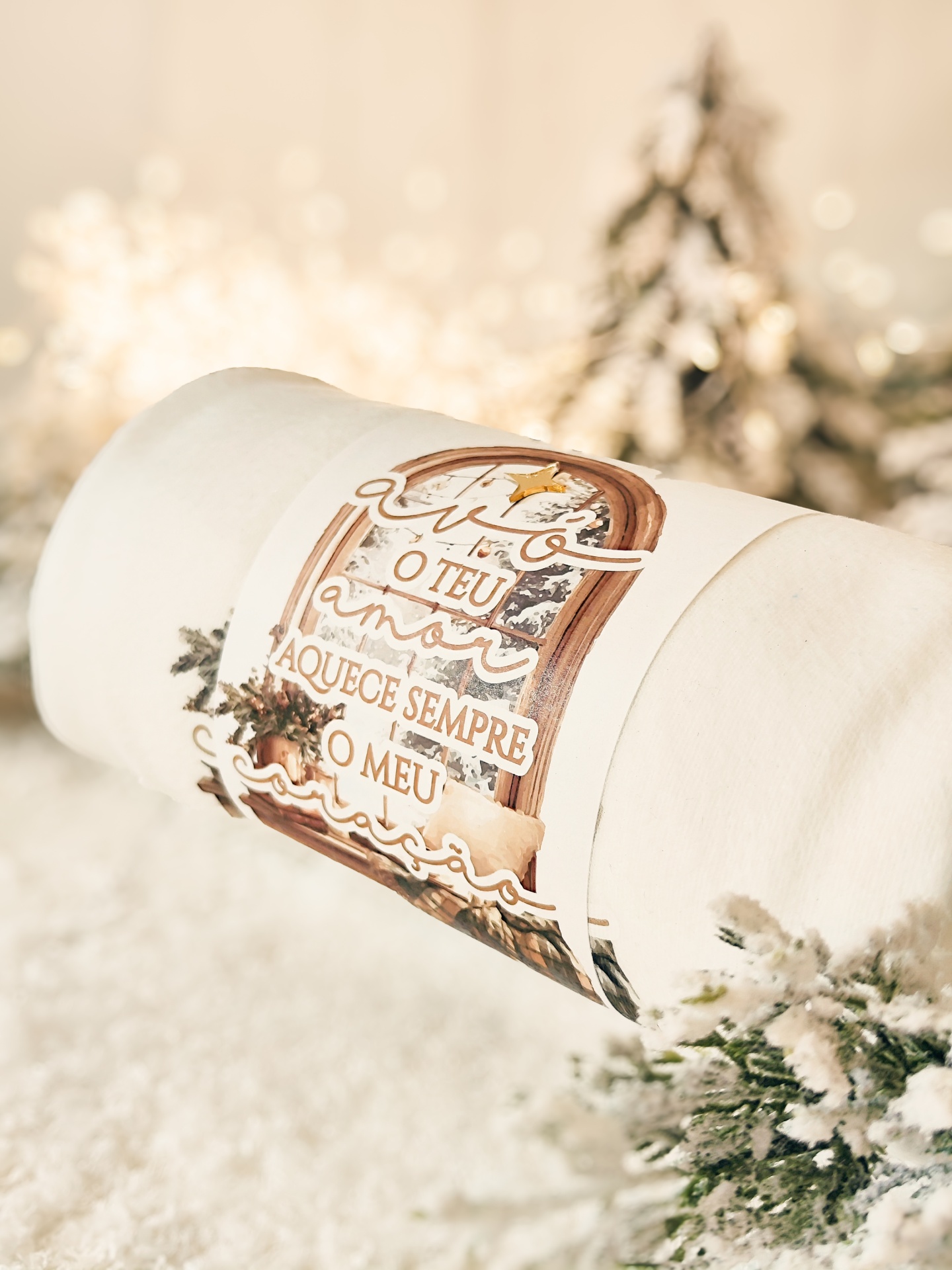 Manta creme com etiqueta de janela e texto em português sobre um fundo de decoração natalícia desfoque