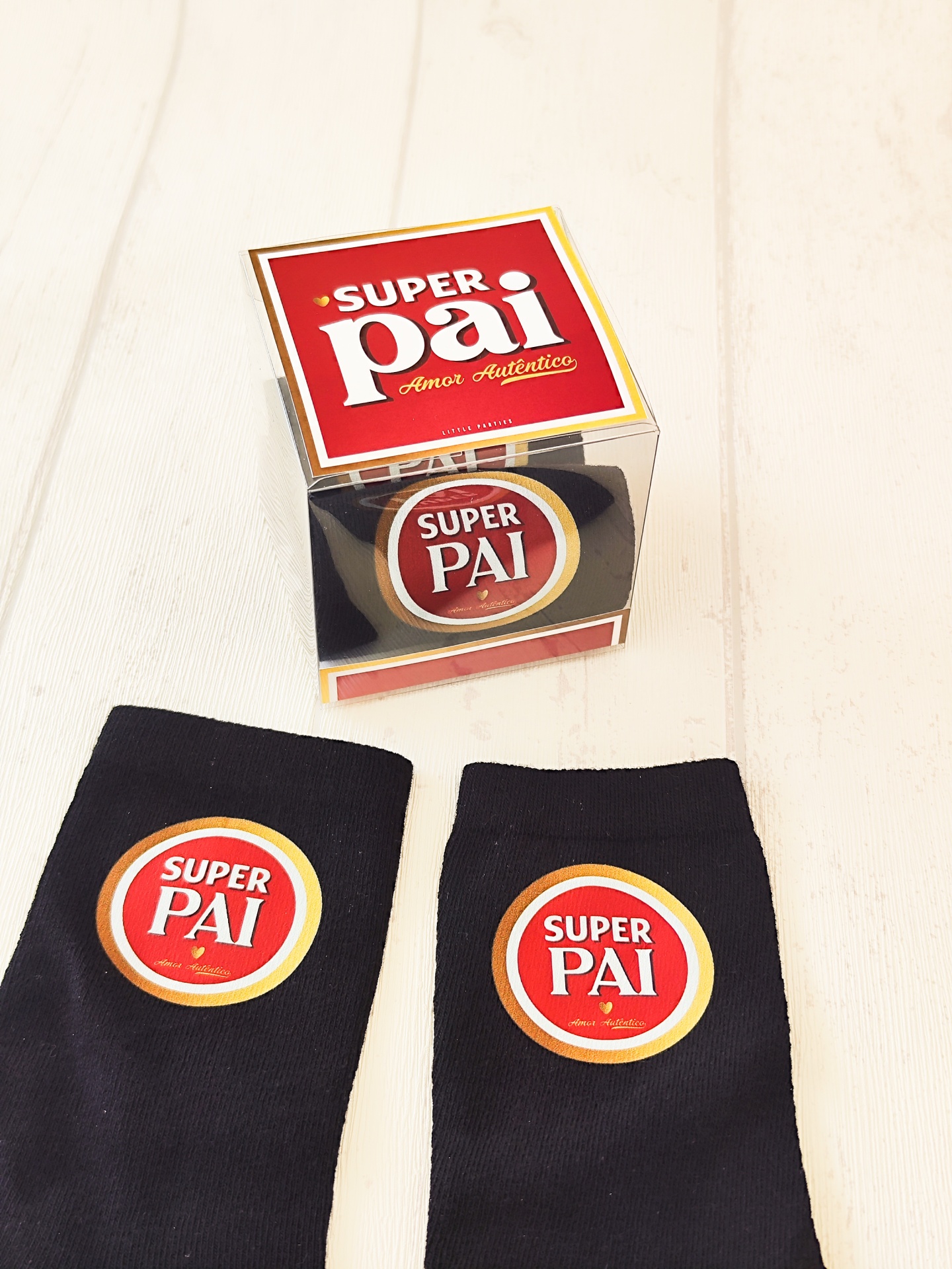 Meias pretas com etiqueta SUPER PAI junto a caixa transparente com texto SUPER pai Amor Autêntico.