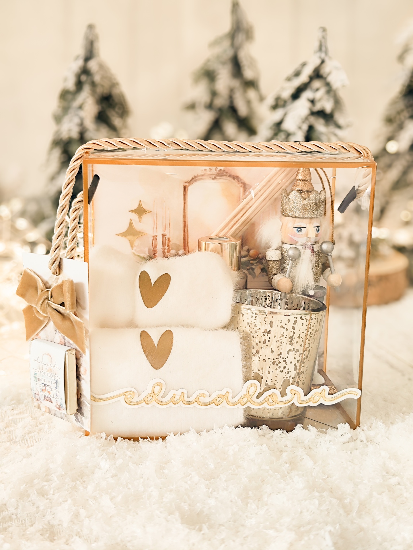 Conjunto de presente com toalhas, castiçal, soldado decorativo em caixa transparente com neve e árvores desfocadas ao fundo
