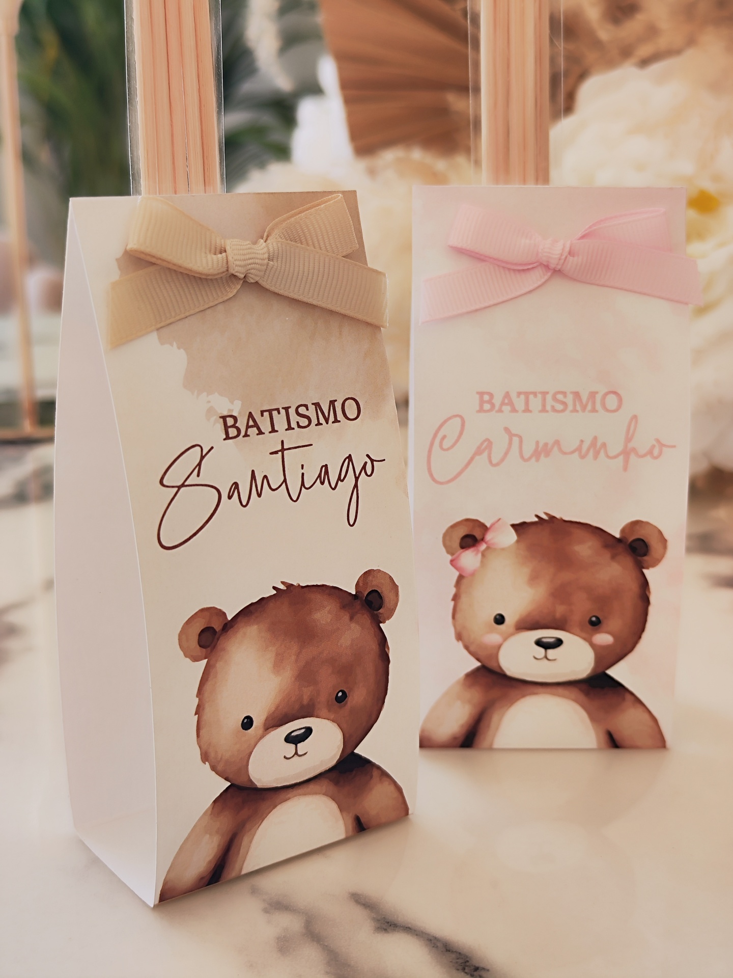 Caixas de lembranças para batismo com desenhos de ursinhos e laços em tons bege e rosa.