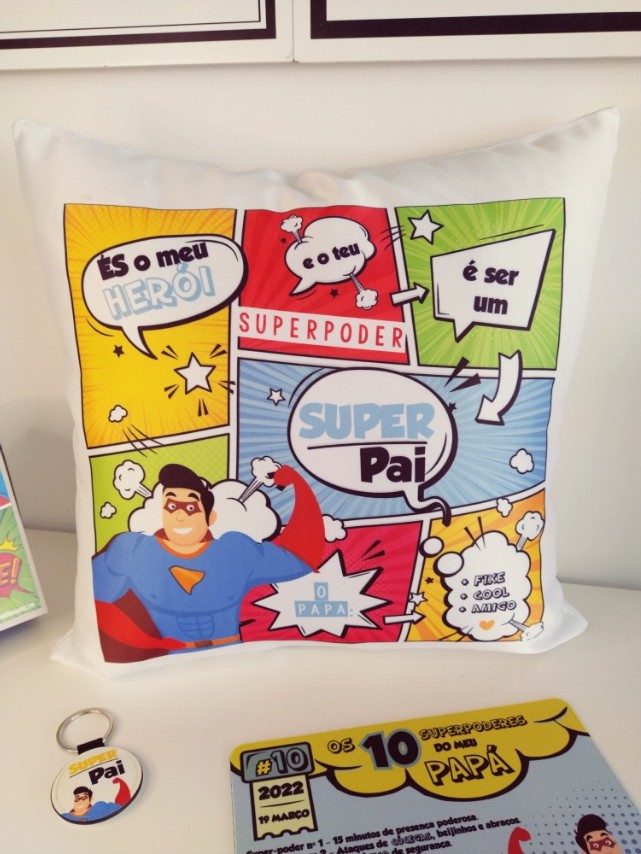 Almofada branca com estampado colorido estilo banda desenhada e frases em português sobre super pai