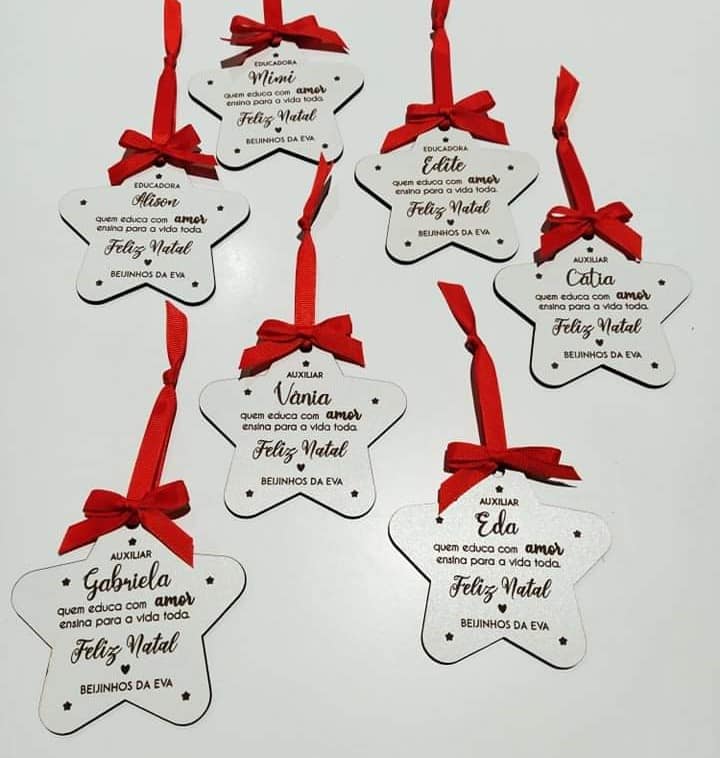 Etiquetas em madeira branca em forma de estrela com laços vermelhos e mensagens de Natal em português