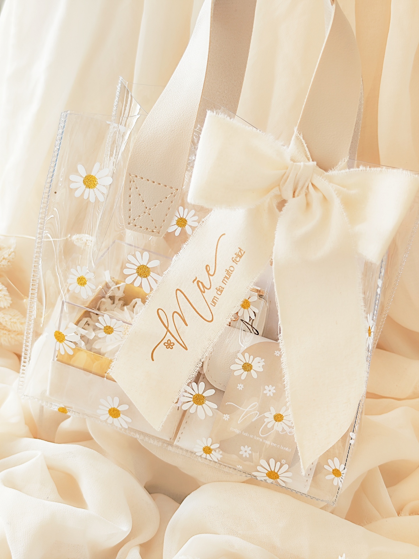 Mala transparente com margaridas, alças bege e laço grande com etiqueta Marie
