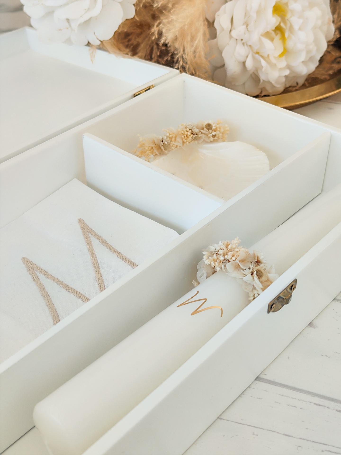 caixa branca com toalha, vela e flores secas decorativas
