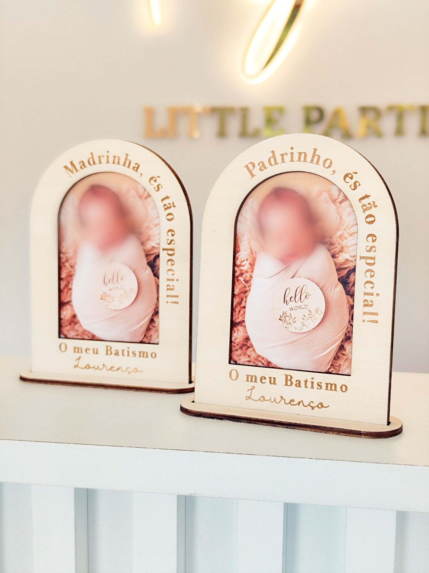 Dois porta-fotos de madeira em forma de arco com fotos de bebés e inscrições em português.