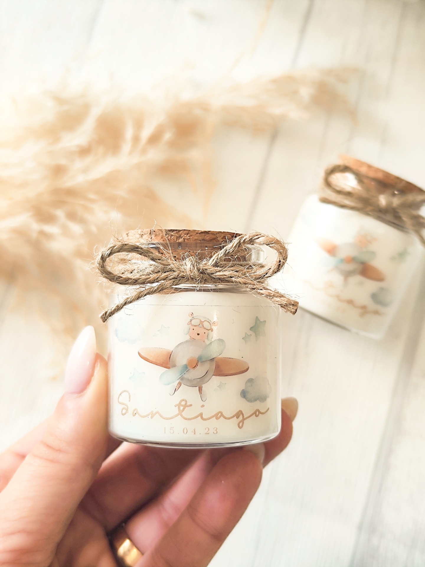 Frasco pequeno com tampa de cortiça, etiqueta com ursinho e avião, texto Santiago 15.04.23